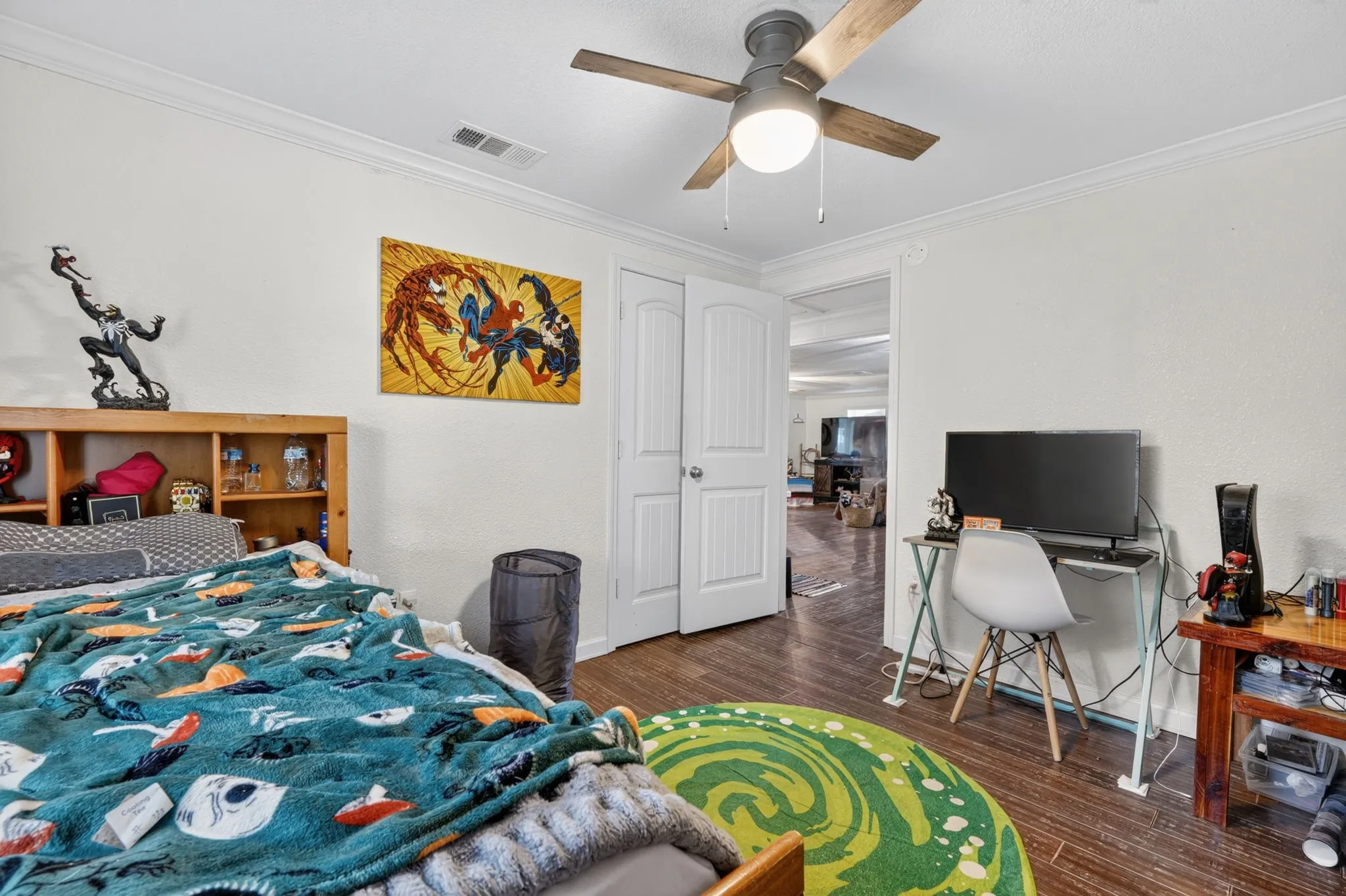 Room featuring wood-finish flooring, a ceiling fan with integrated lighting, crown molding, and white trim