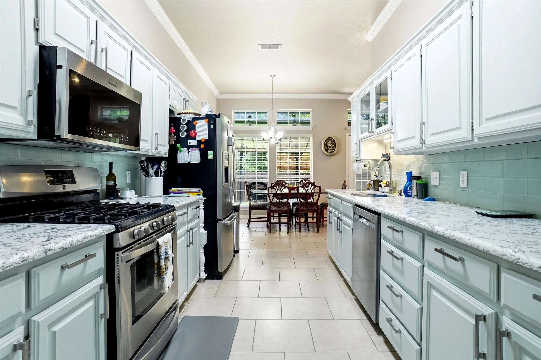upper cabinets in white and lower cabinets in accent shade, gas range & stainless appliances