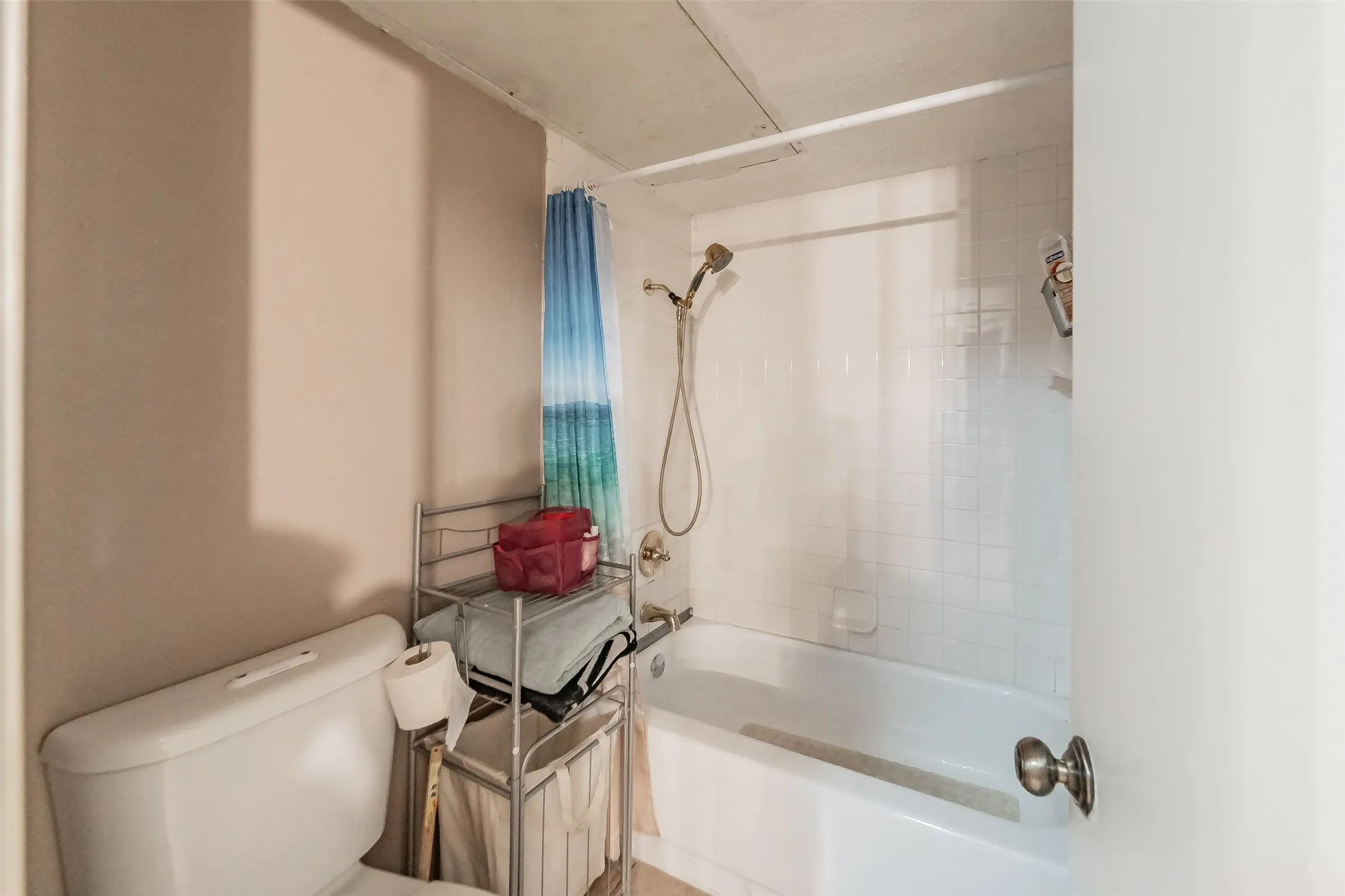 White bathtub with a tiled surround and a shower fixture