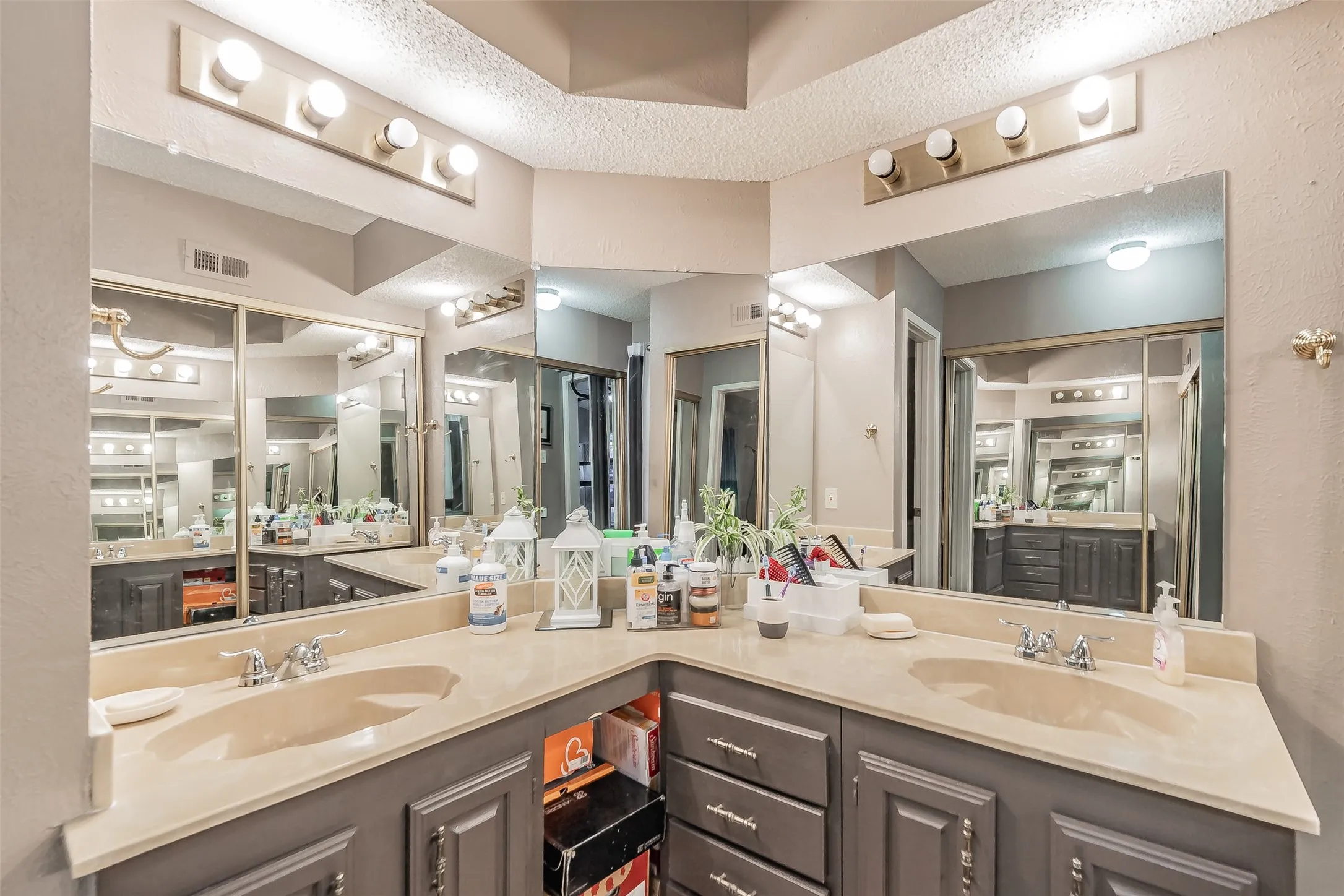 Dual vanity with integrated sinks and a light-toned countertop, featuring a corner configuration