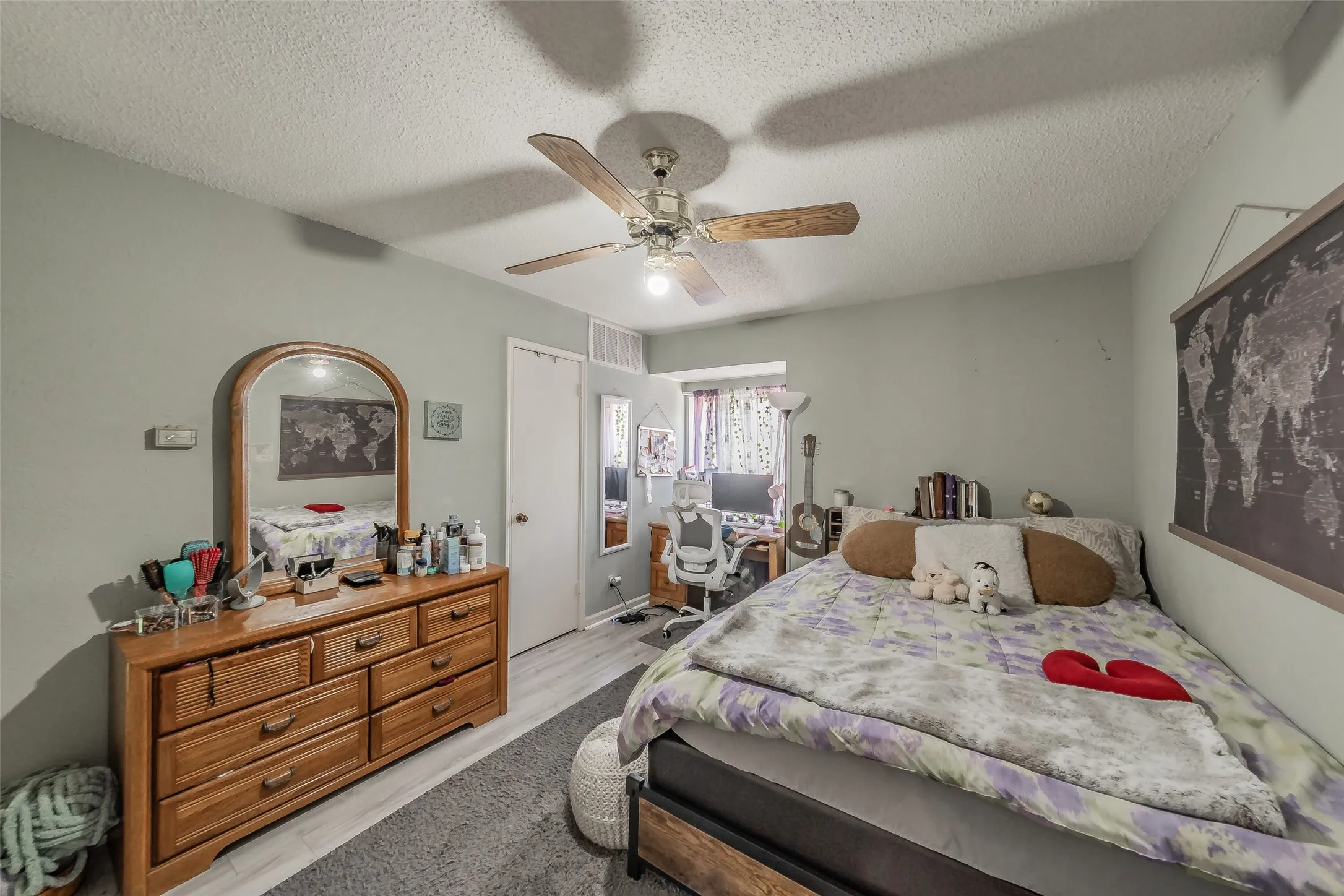 Interior room featuring light-toned walls, wood-finish flooring, and a ceiling fan with integrated lighting