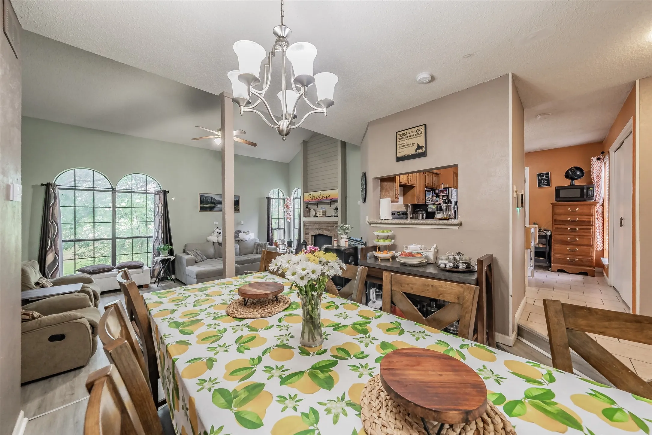 Open concept living area featuring vaulted ceilings, a central chandelier, and arched windows