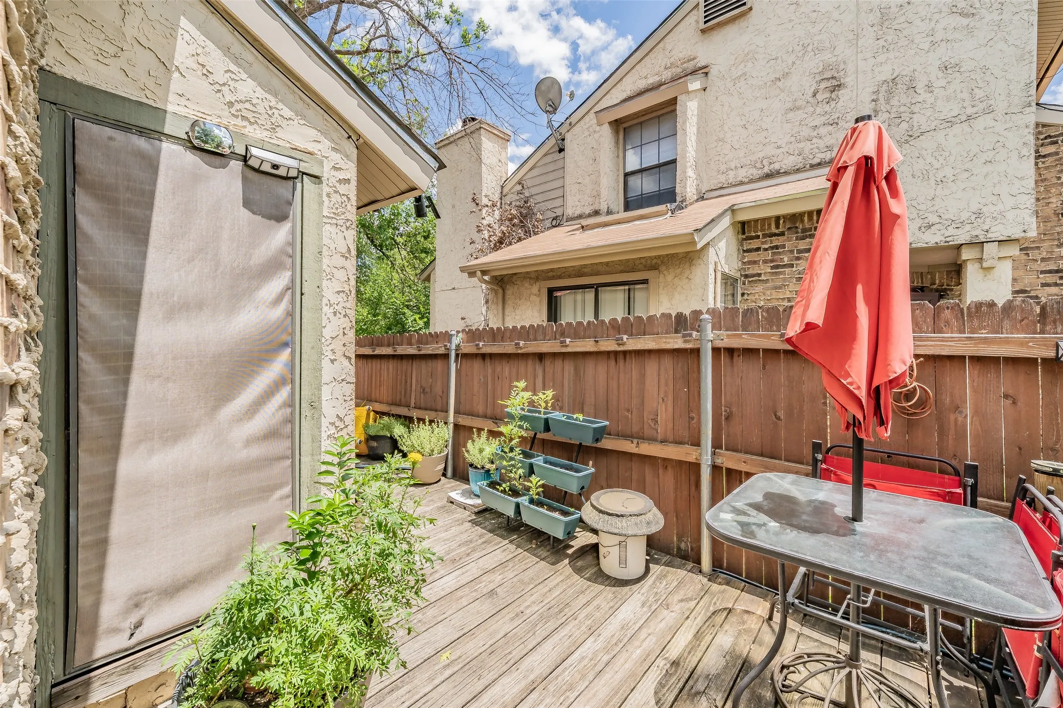 Private outdoor patio featuring wood decking and a privacy fence