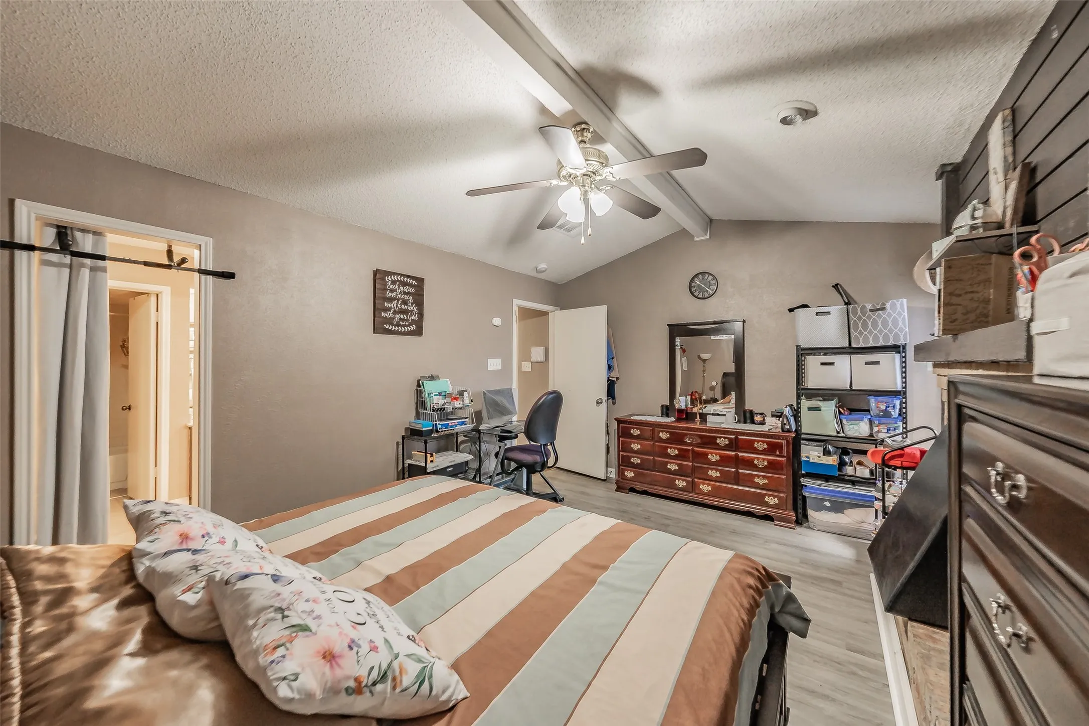 Vaulted ceiling with exposed beams and ceiling fan