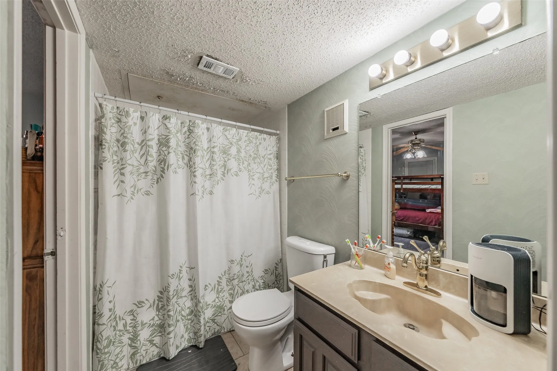 Bathroom vanity featuring a single basin sink, light-toned countertop, and dark wood-finish cabinetry