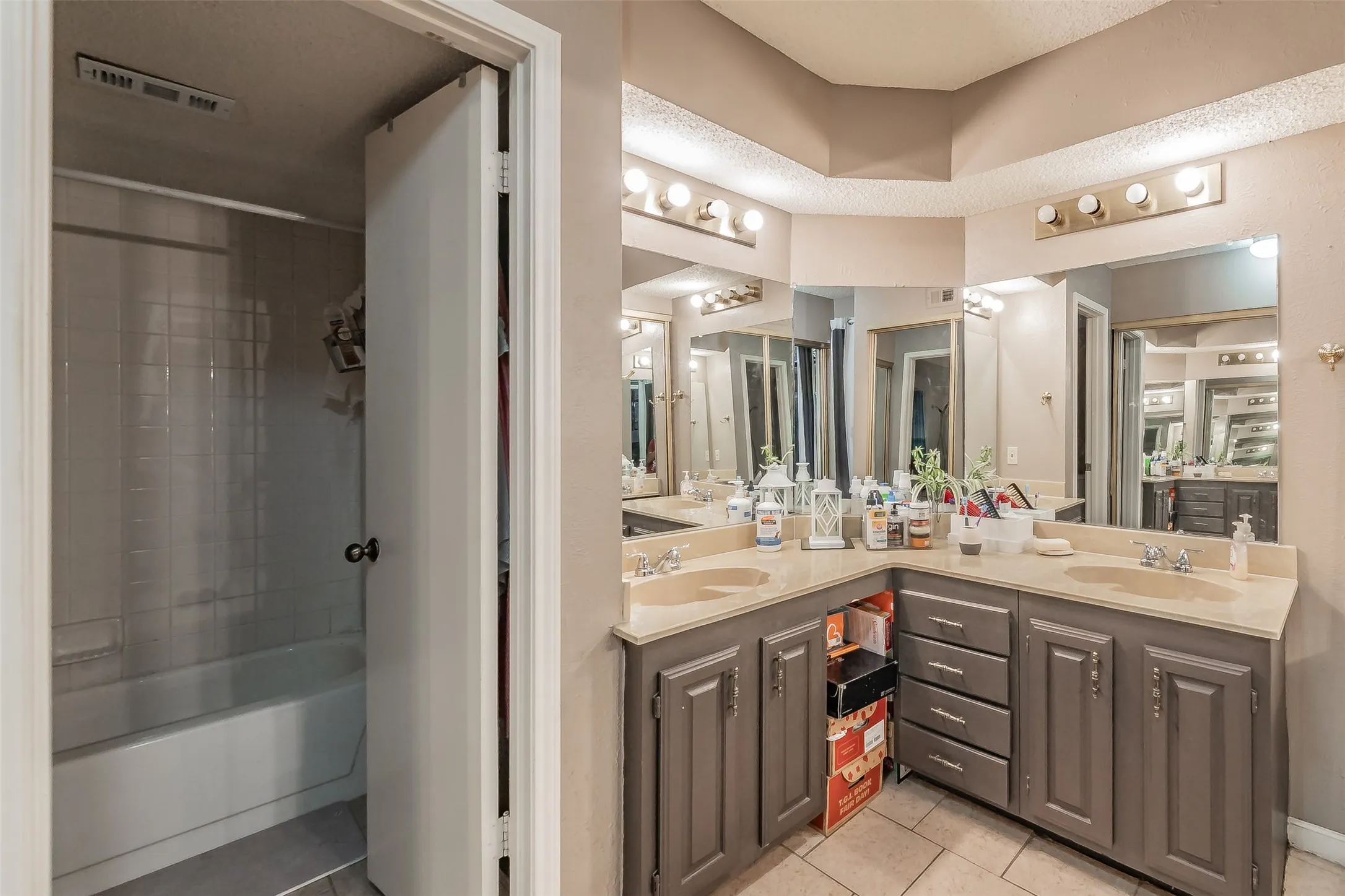 Bathroom featuring dual vanity with beige countertops and integrated sinks