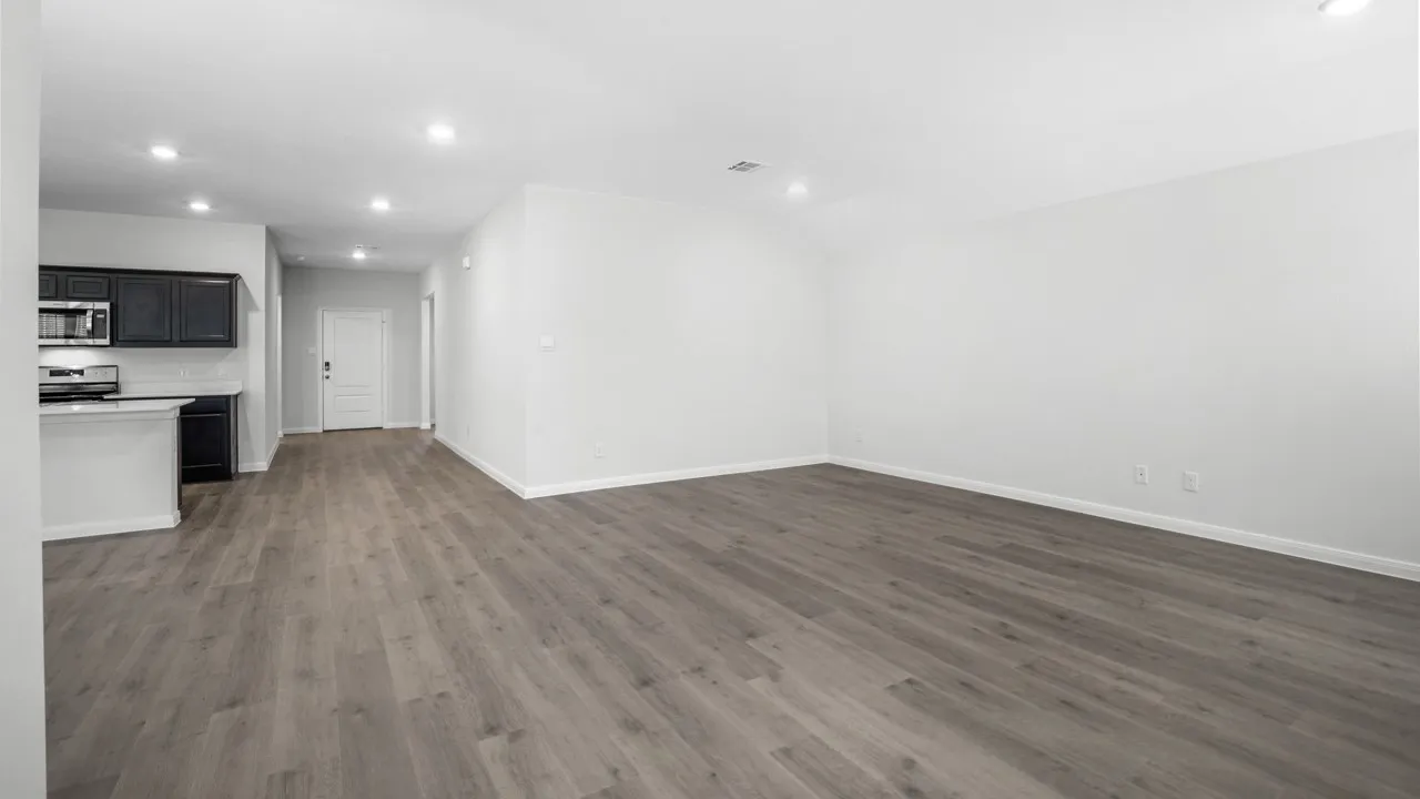 Open-concept living space featuring wood-finish flooring, recessed lighting, and white walls