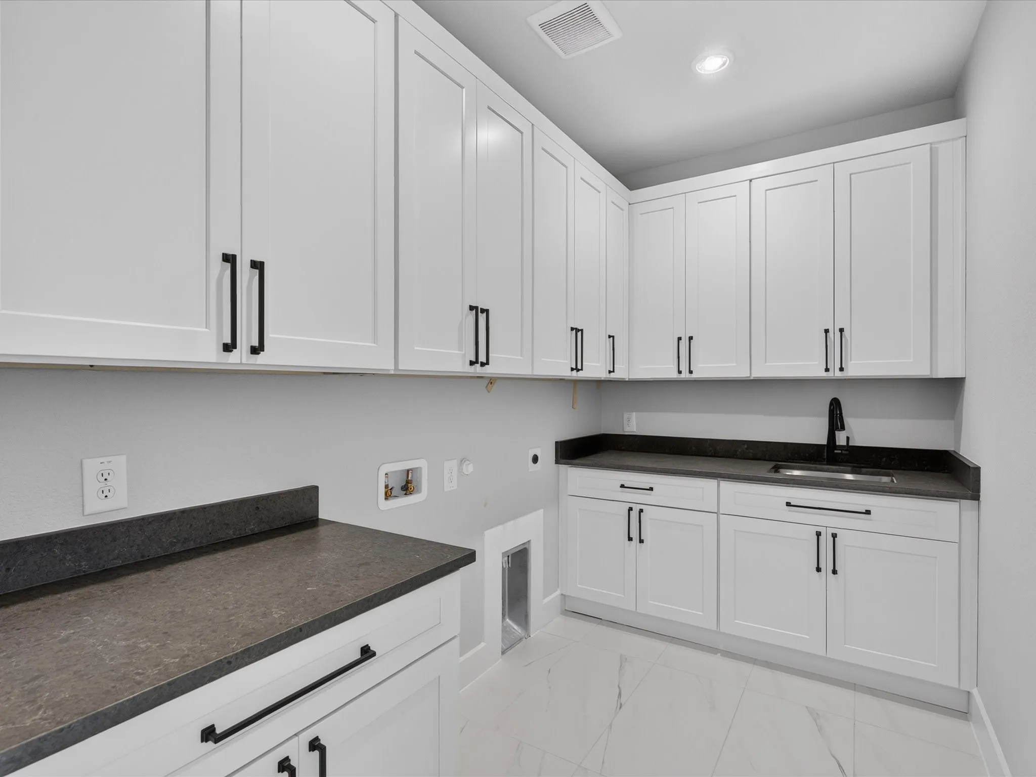 White shaker-style cabinetry with matte black hardware