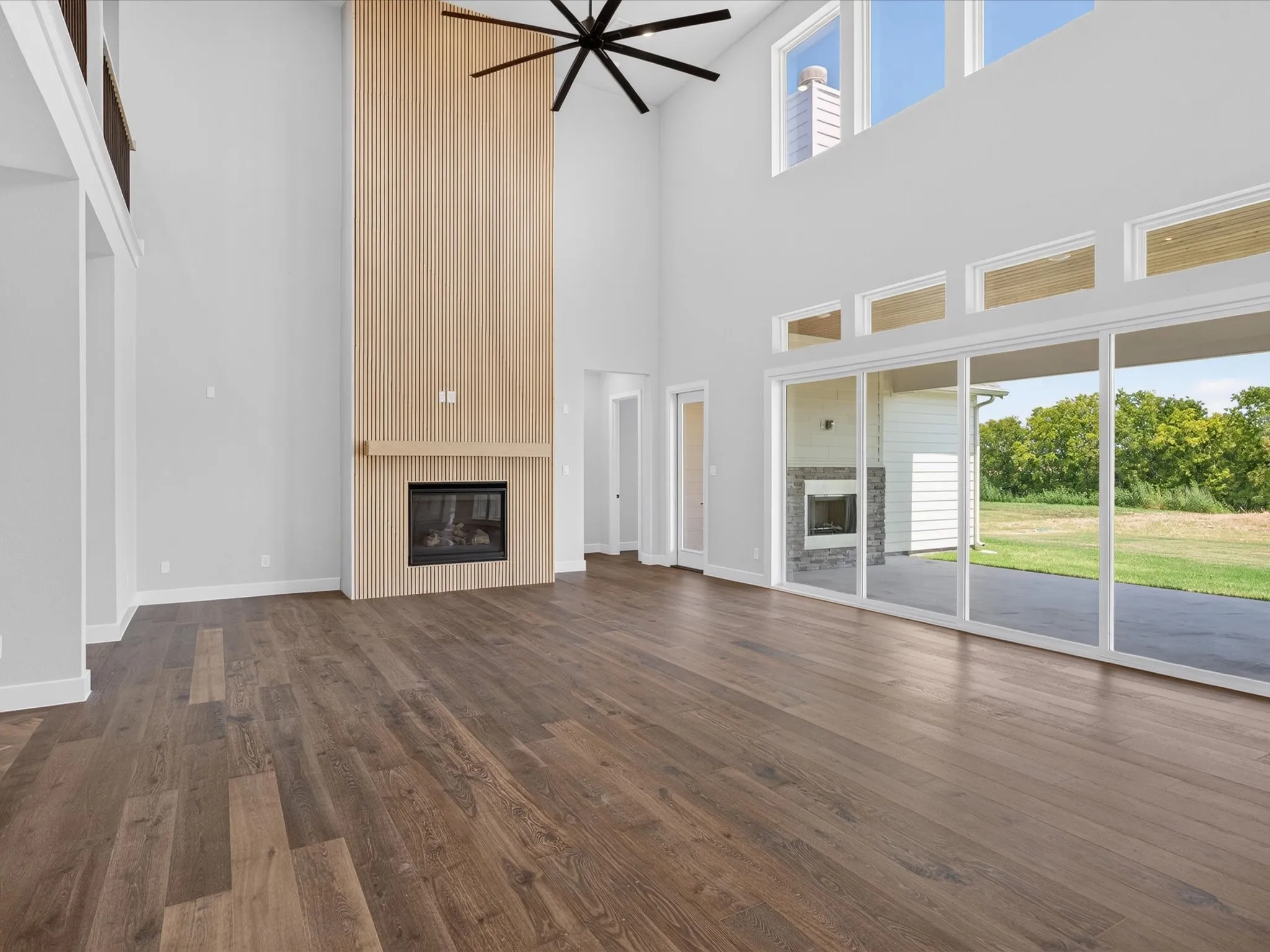 Wood-finish flooring throughout, with a fireplace featuring a wood-paneled surround and mantel