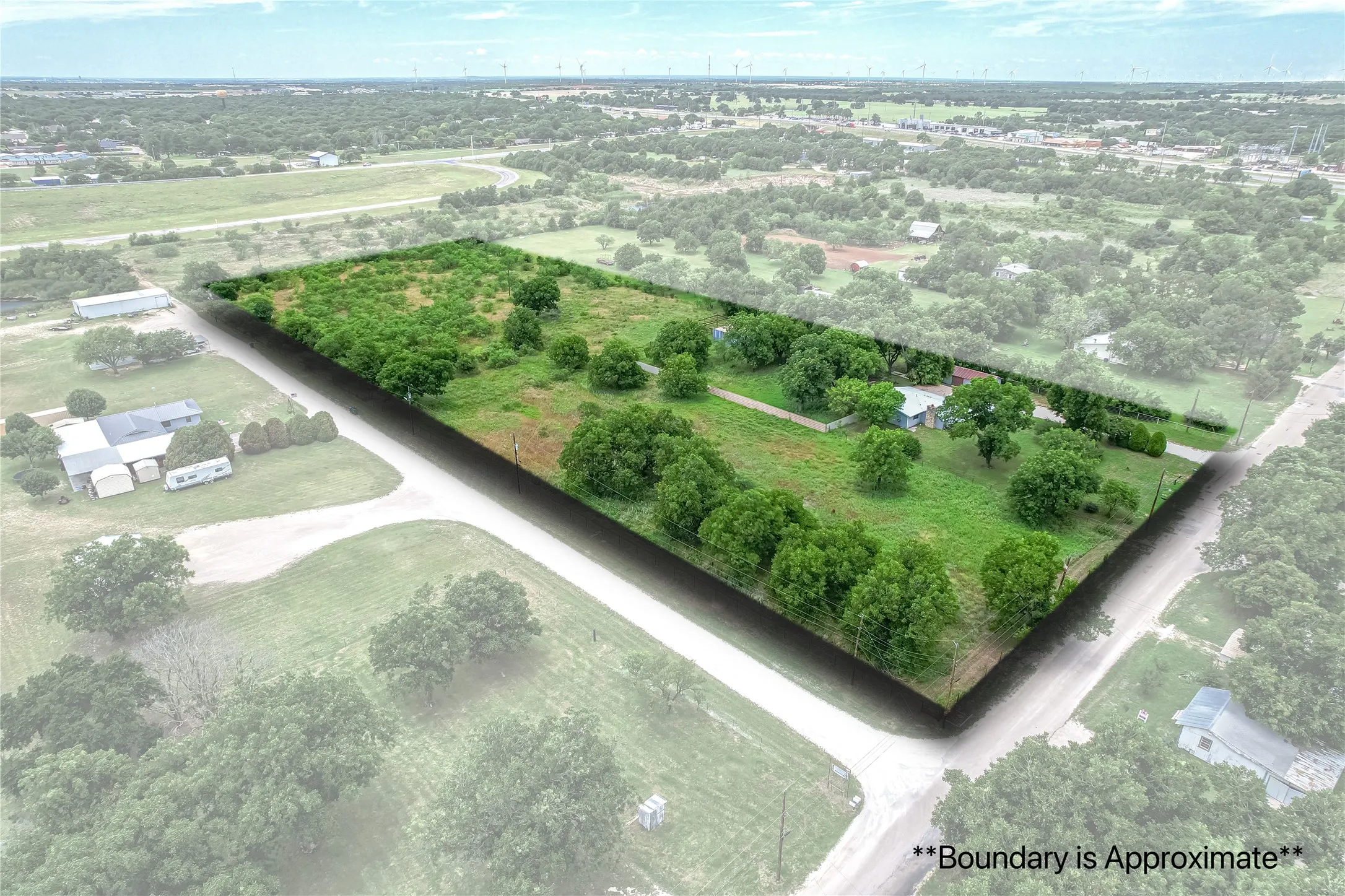 Expansive lot with varied topography, including open grassy areas and dense tree coverage