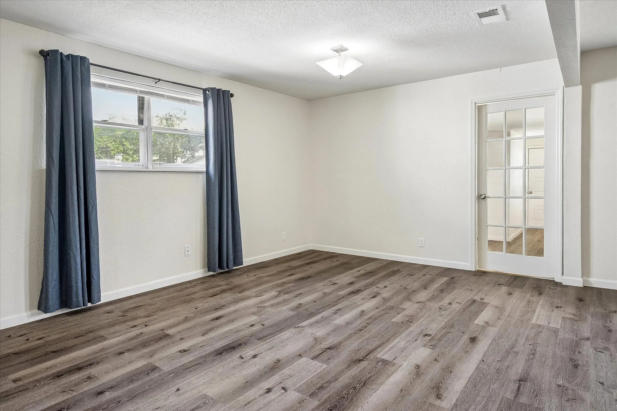 Living room area with door to the bonus room and utility room.