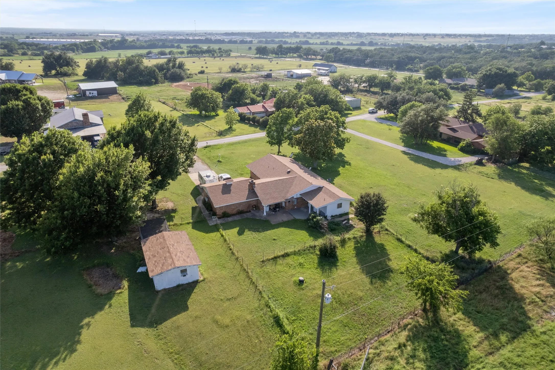 Expansive property featuring a single-story residence with a brick exterior and a separate outbuilding
