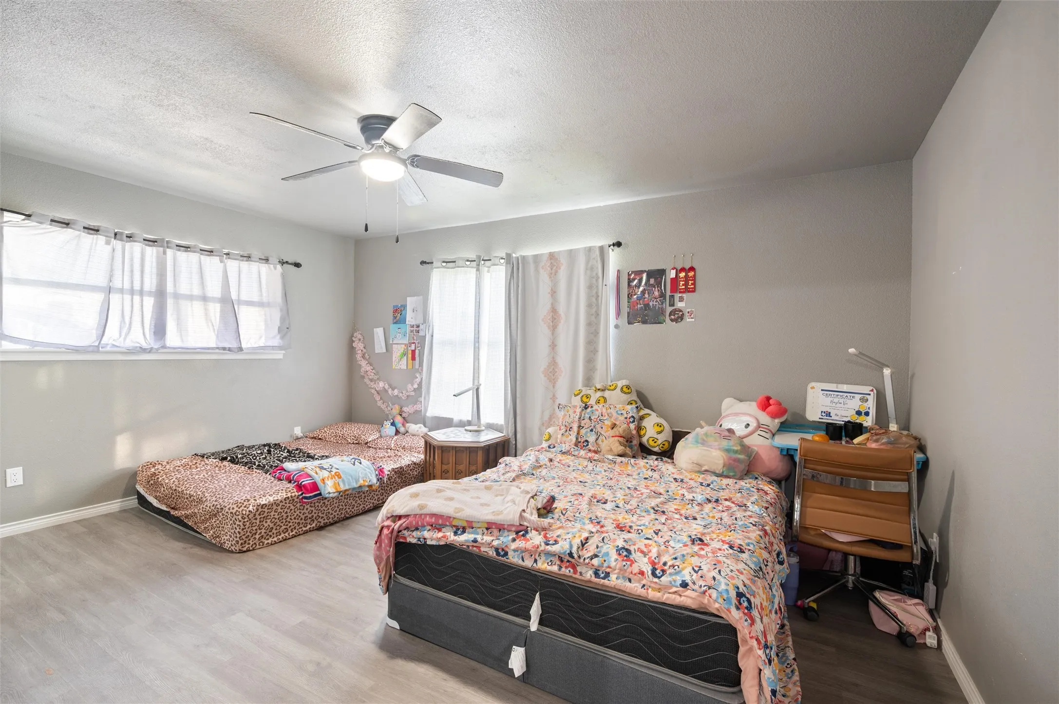 Spacious room featuring light gray walls and wood-finish flooring