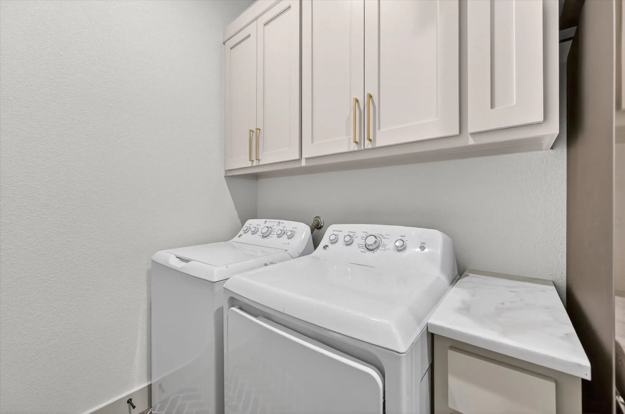 White shaker-style cabinetry with gold-tone hardware