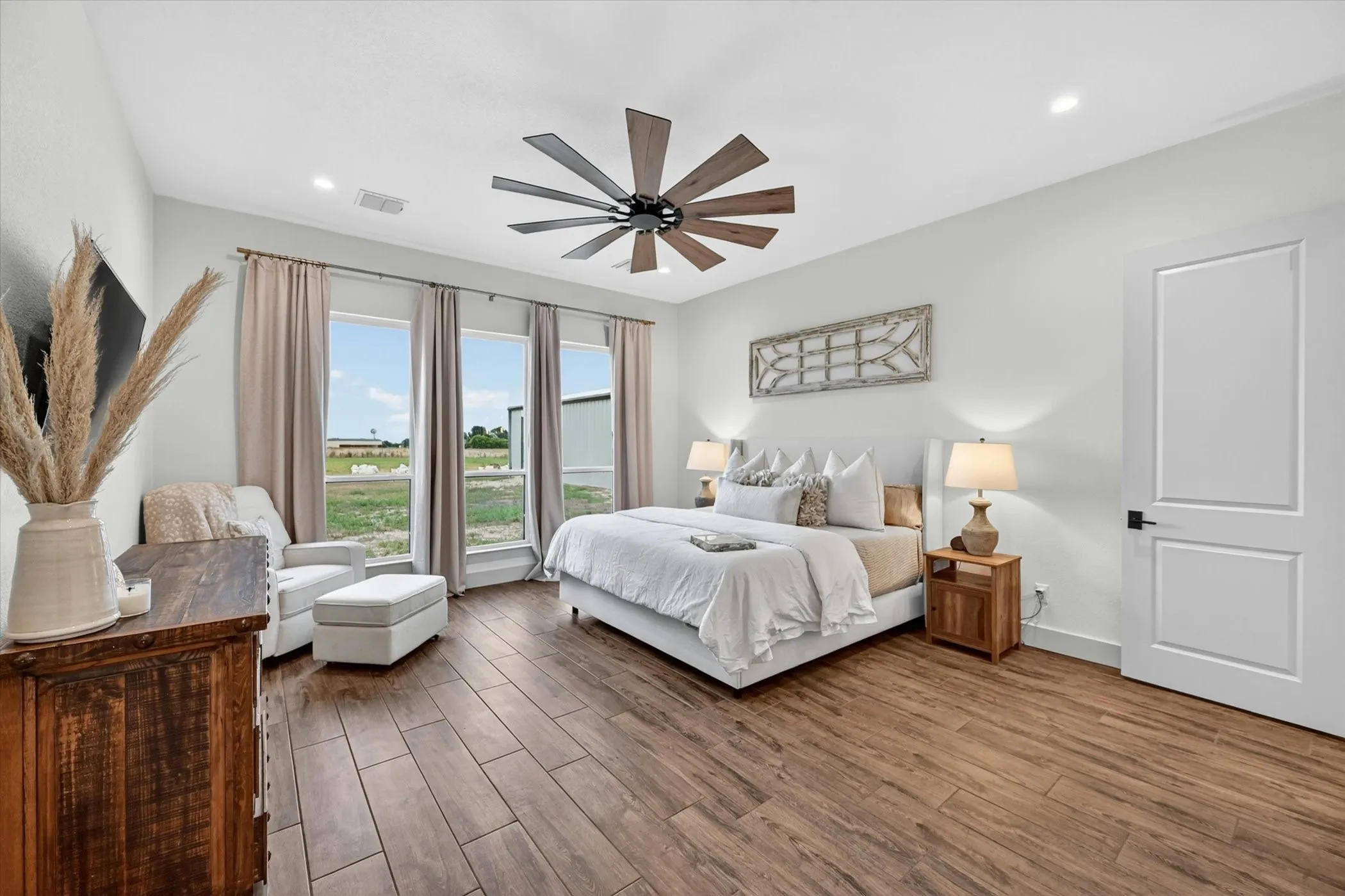 Spacious room featuring wood-look tile flooring, a contemporary ceiling fan, recessed lighting, and a light beige panel door