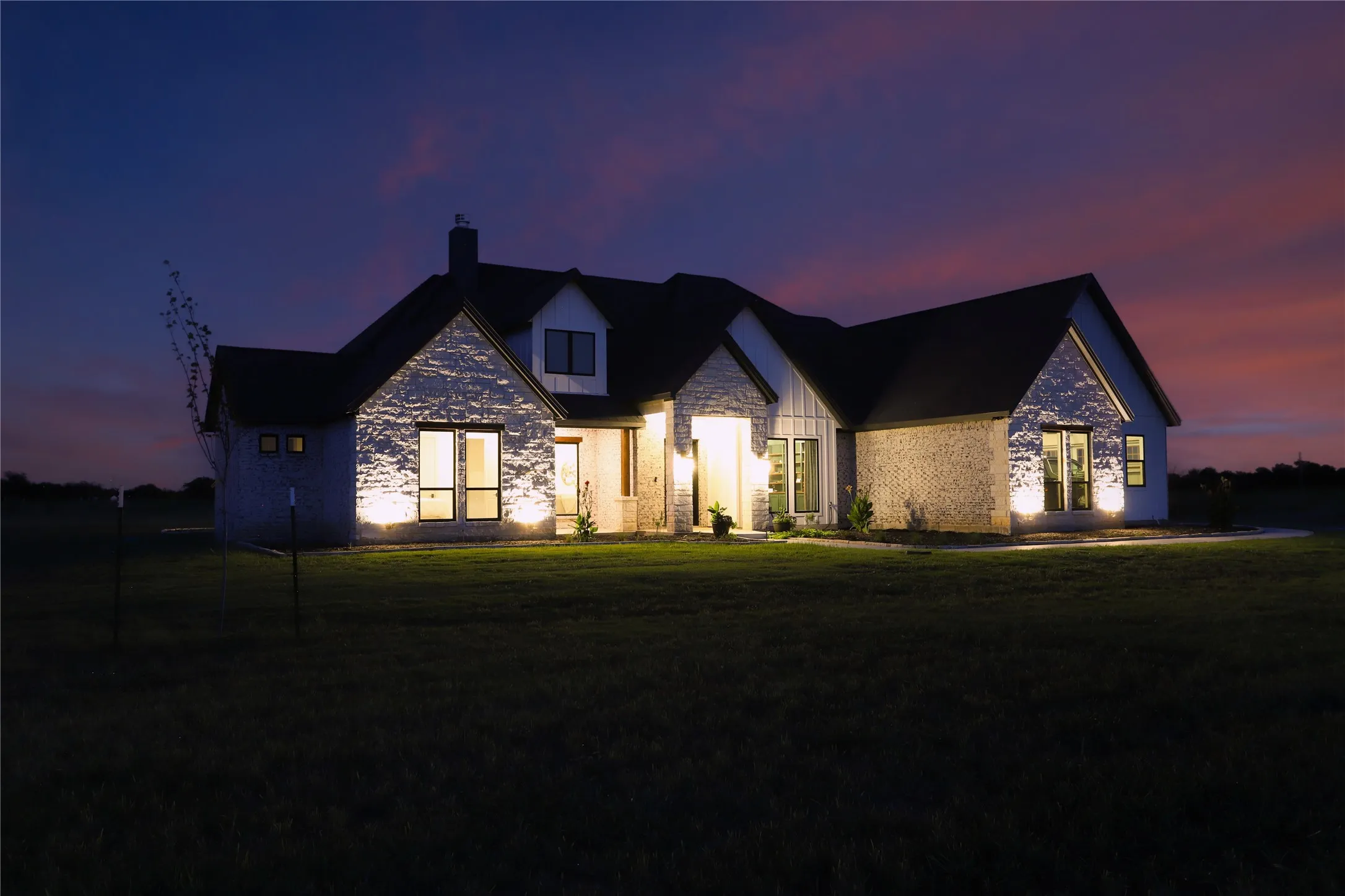 Exterior featuring stone and vertical siding accents, gabled rooflines, and multiple windows