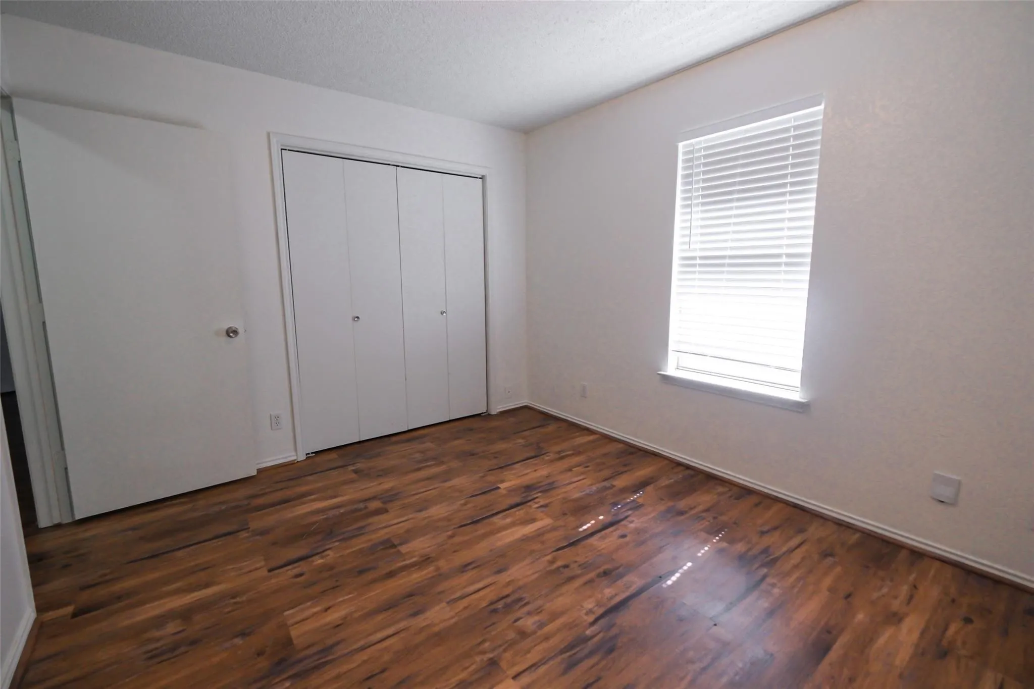 Hardwood-style flooring with white baseboards throughout
