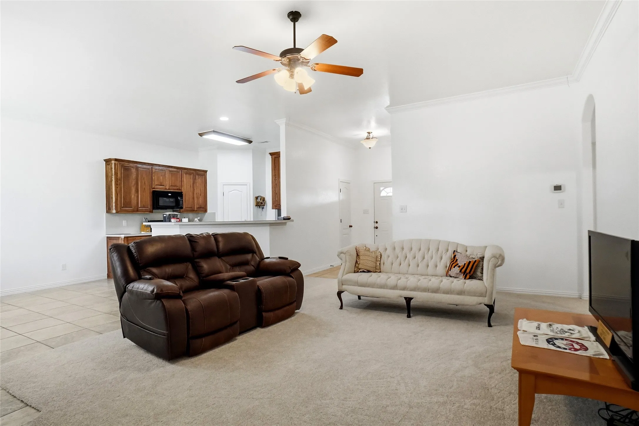 Open concept living area featuring a vaulted ceiling and a ceiling fan