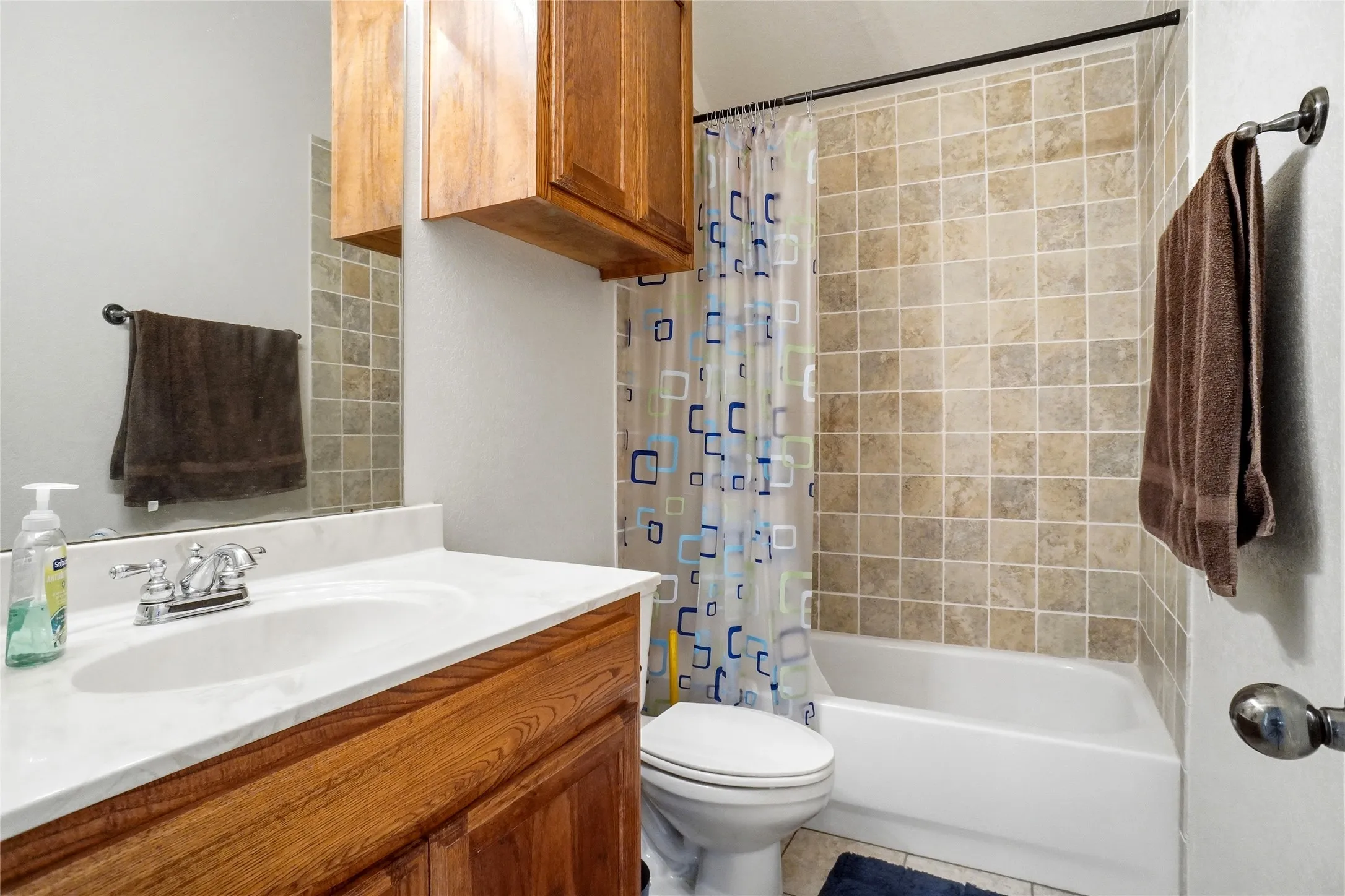 Bathroom with a white vanity featuring a built-in sink, chrome fixtures, and a light-colored countertop