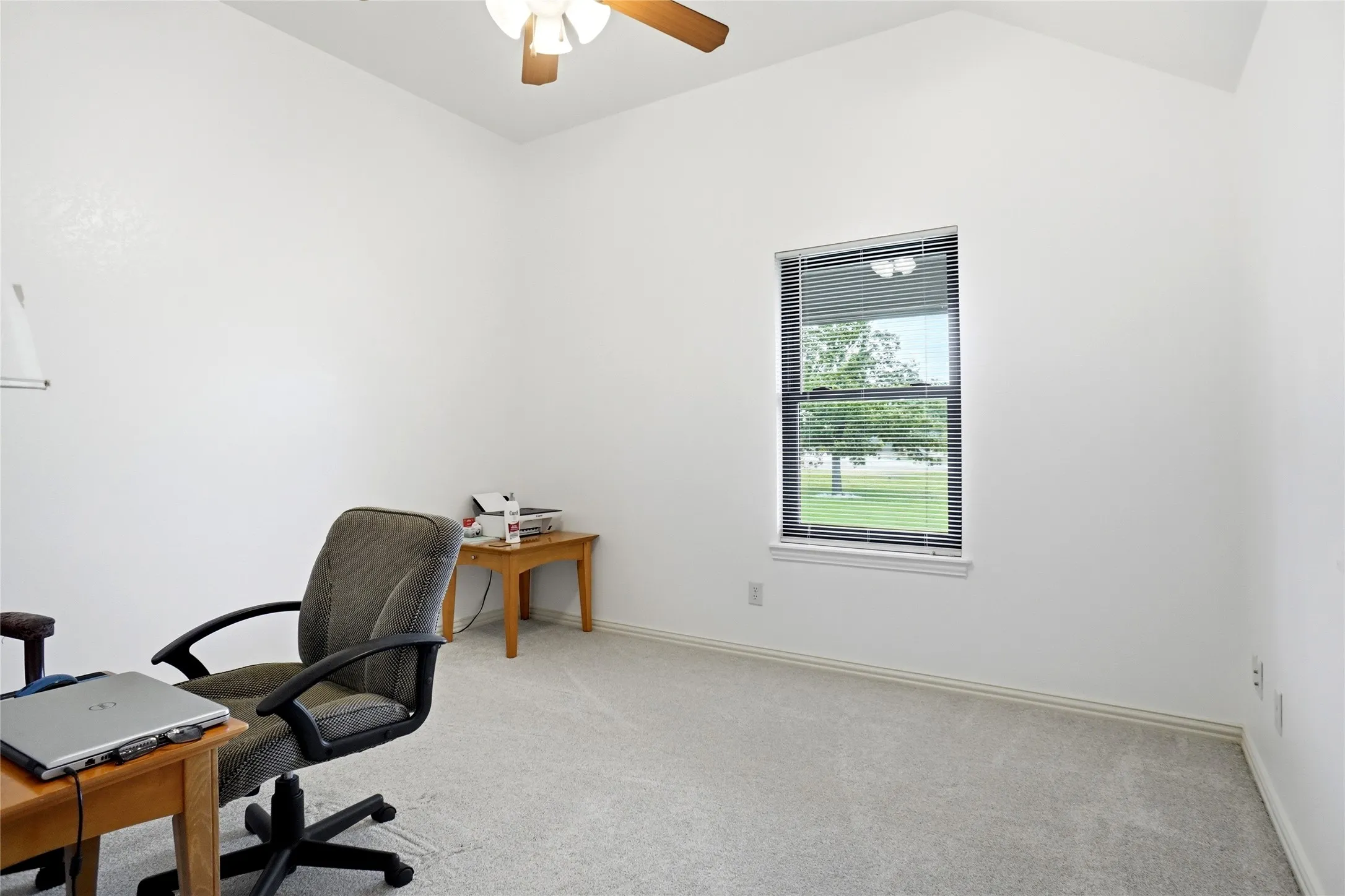 Interior room featuring vaulted ceilings, light-colored carpeting, and a window with horizontal blinds