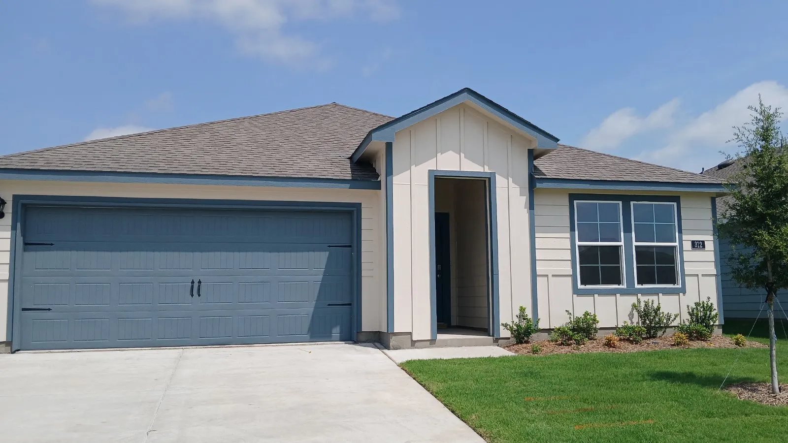 Contemporary single-story residence featuring a two-car garage, a covered entry, horizontal siding, and a gabled roofline