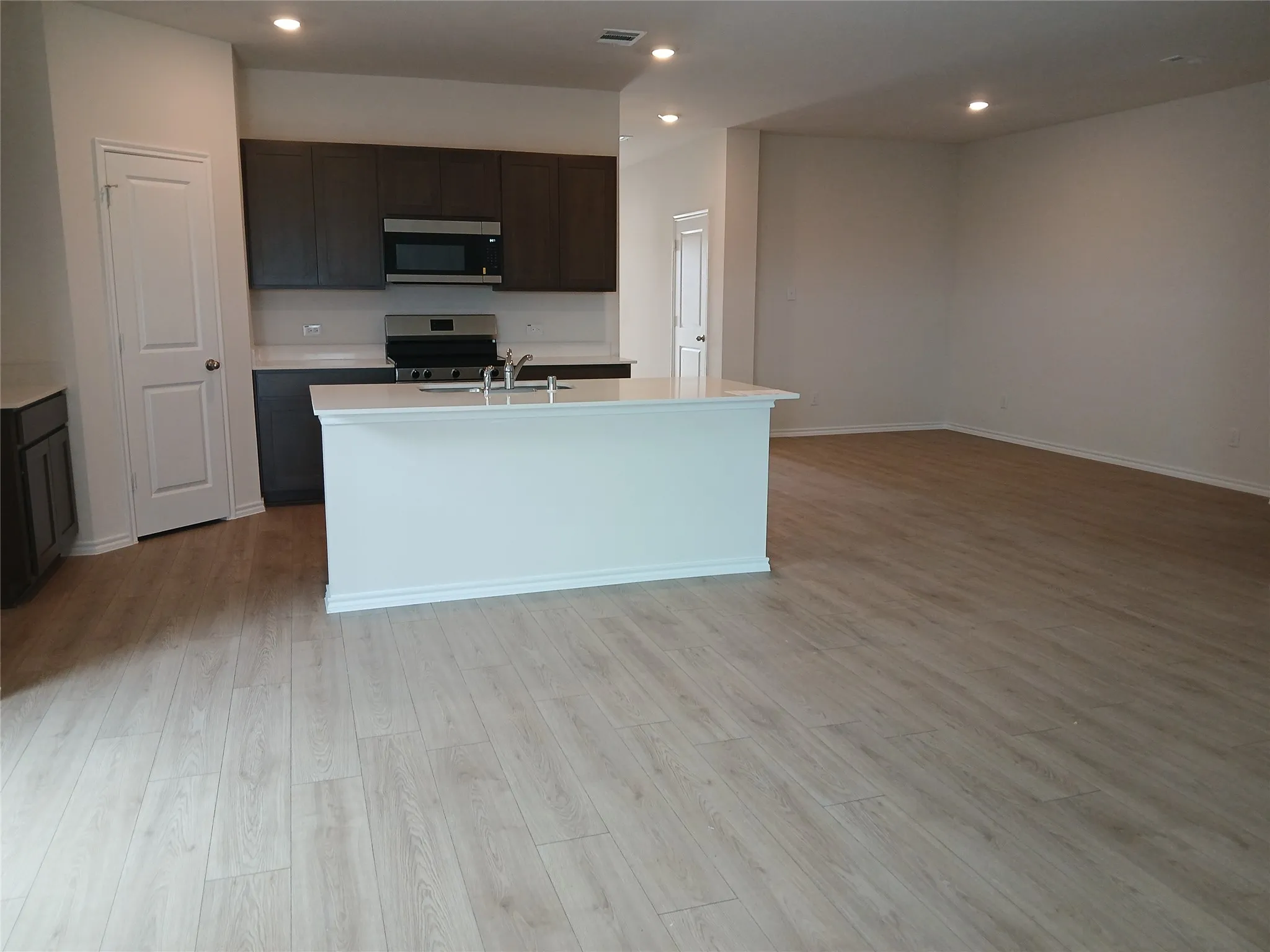 Open-concept living space featuring wood-finish flooring throughout
