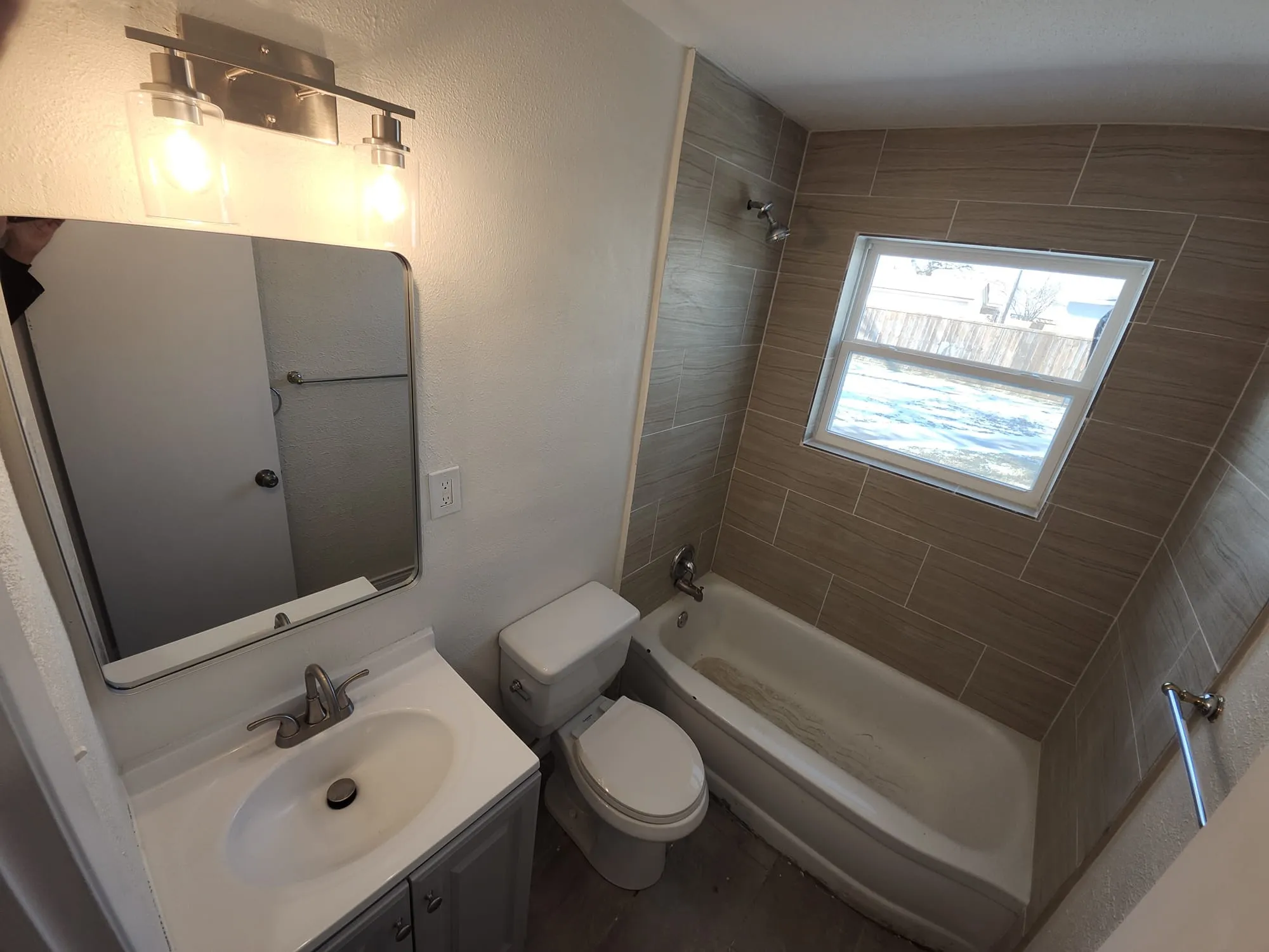 Bathroom featuring a fully tiled shower surround with a built-in window
