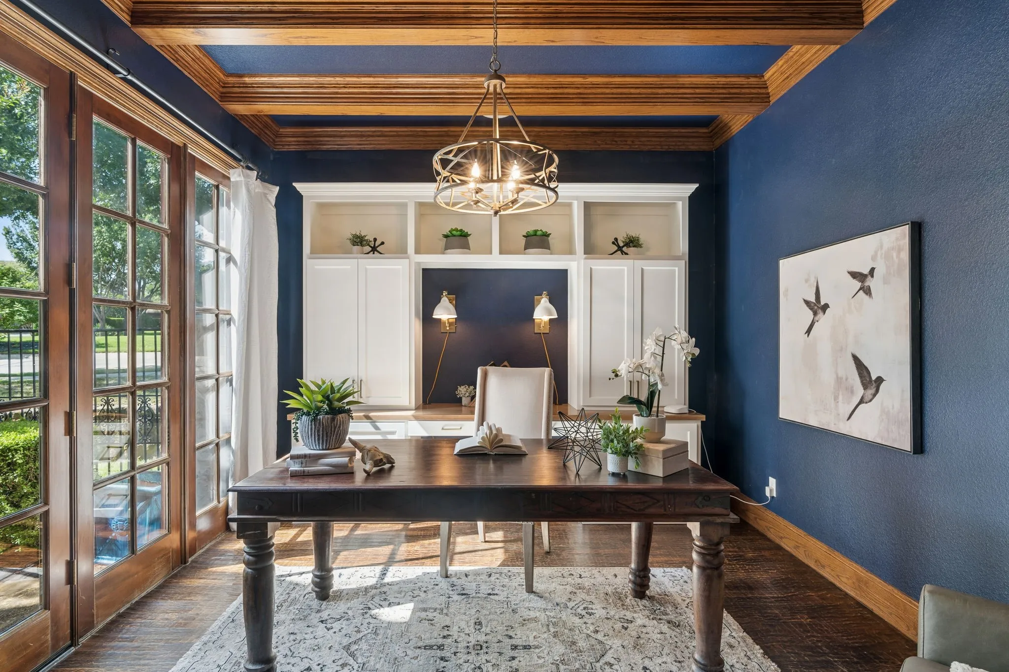 The private office at 2601 Sir Castor Court boasts  built-in cabinetry, a coffered ceiling, and accent wall lighting.