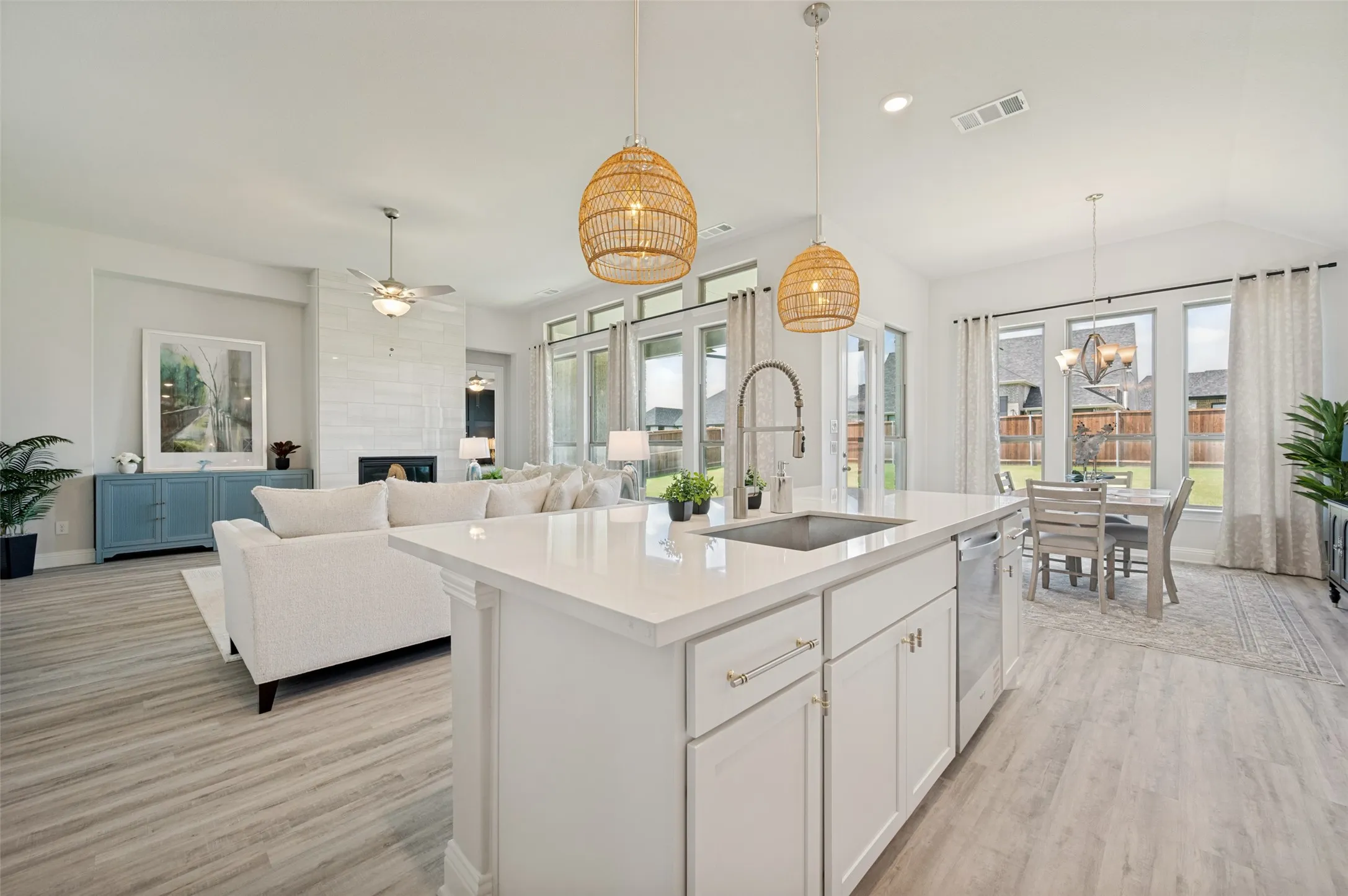 The heart of the home is this breathtaking open-concept living space, where a sprawling quartz island, designer lighting, soaring ceilings, and expansive windows create an exceptional environment for entertaining. Flooded with natural light and thoughtfully designed for modern living, the kitchen, dining, and family room flow together seamlessly, offering both elegance and functionality