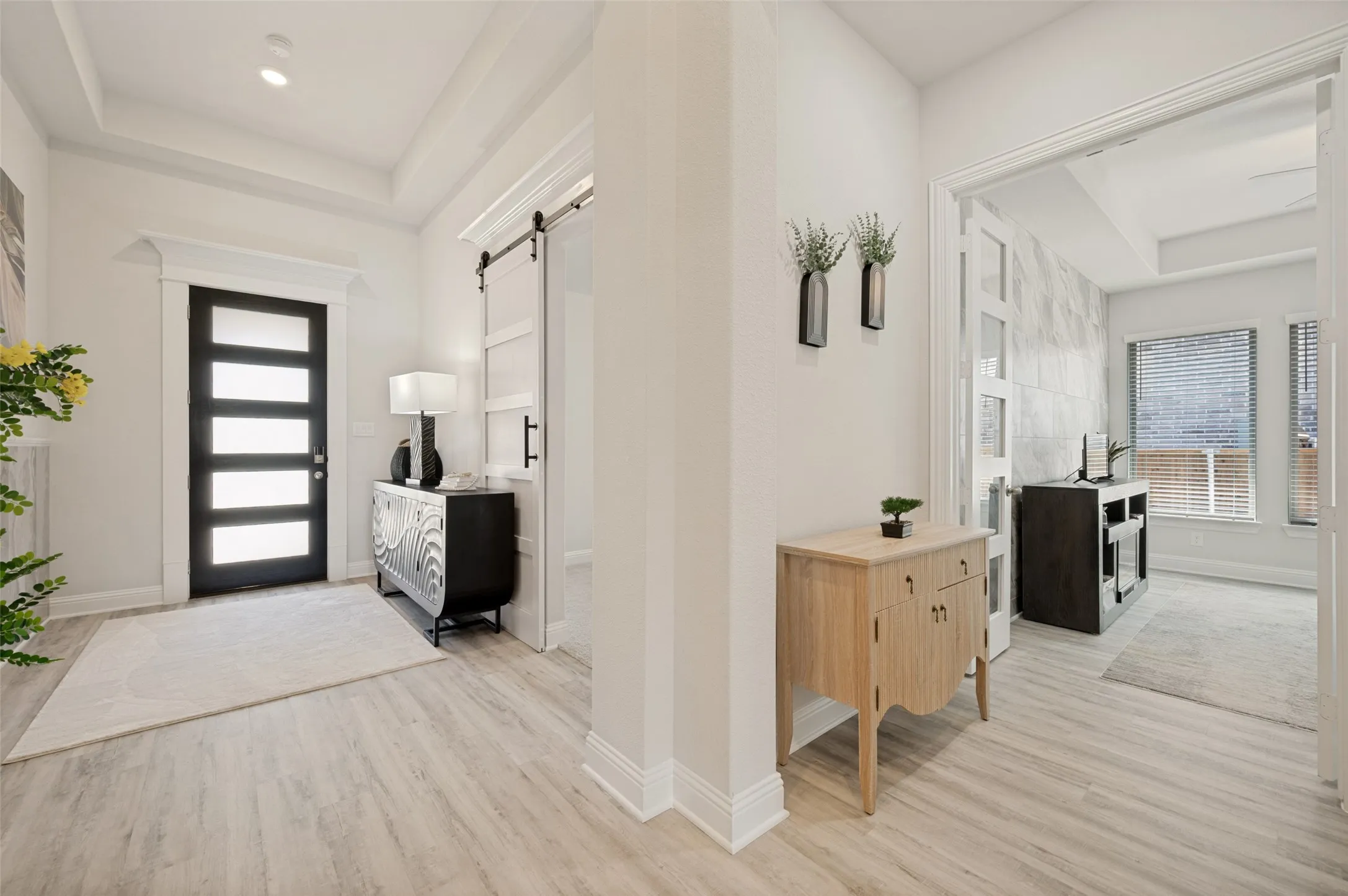 Step inside to a bright and inviting foyer where soaring ceilings, elegant architectural details, and abundant natural light create a warm welcome. The contemporary front door, designer finishes, and stylish accents set the stage for the sophisticated living spaces that await beyond.