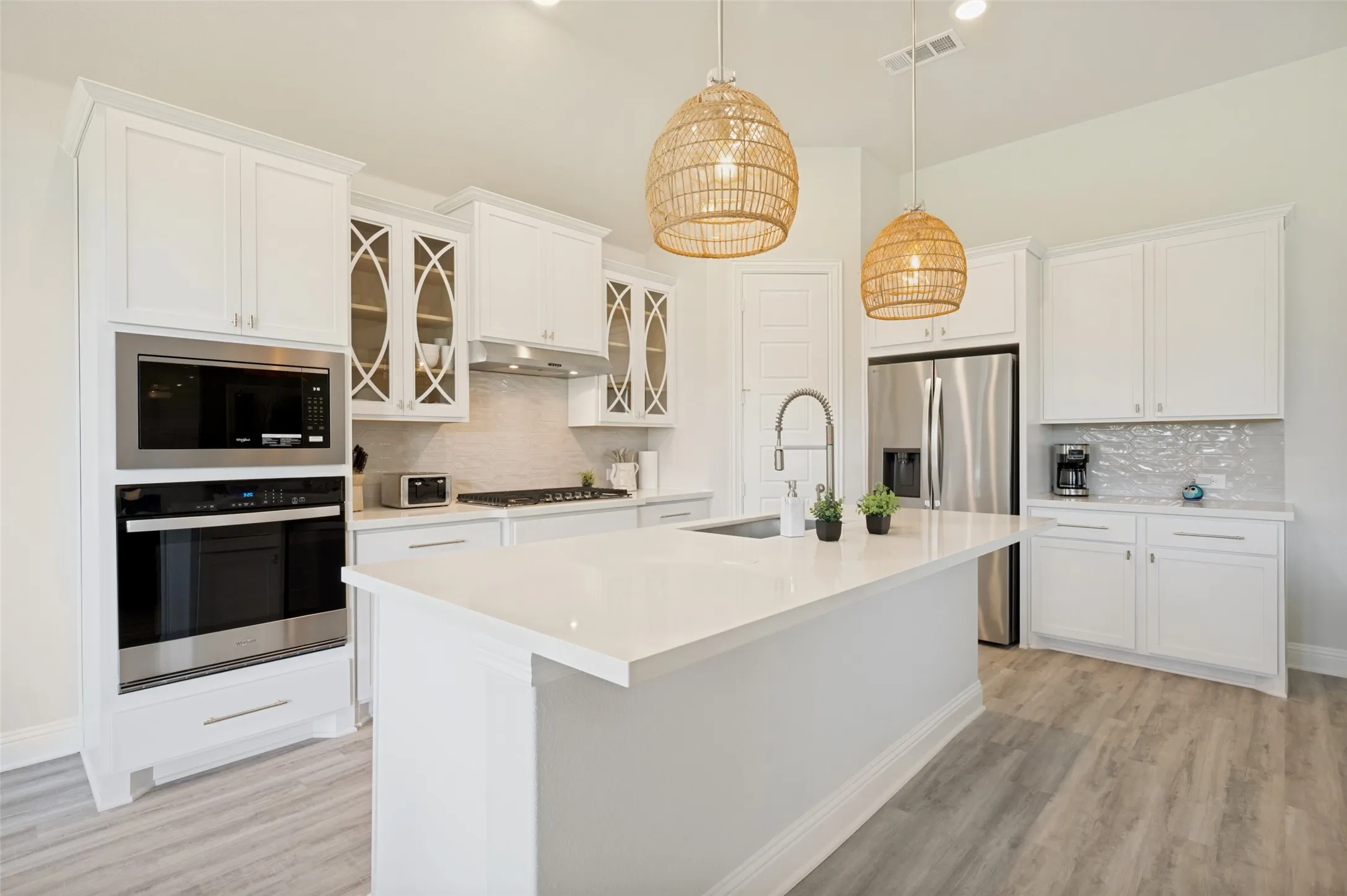 At the center of the home, this stunning chef's kitchen showcases a sprawling quartz island, double ovens, stainless steel appliances, and abundant storage. Thoughtfully designed for entertaining, the open layout blends style and functionality while creating a natural gathering space for family and friends