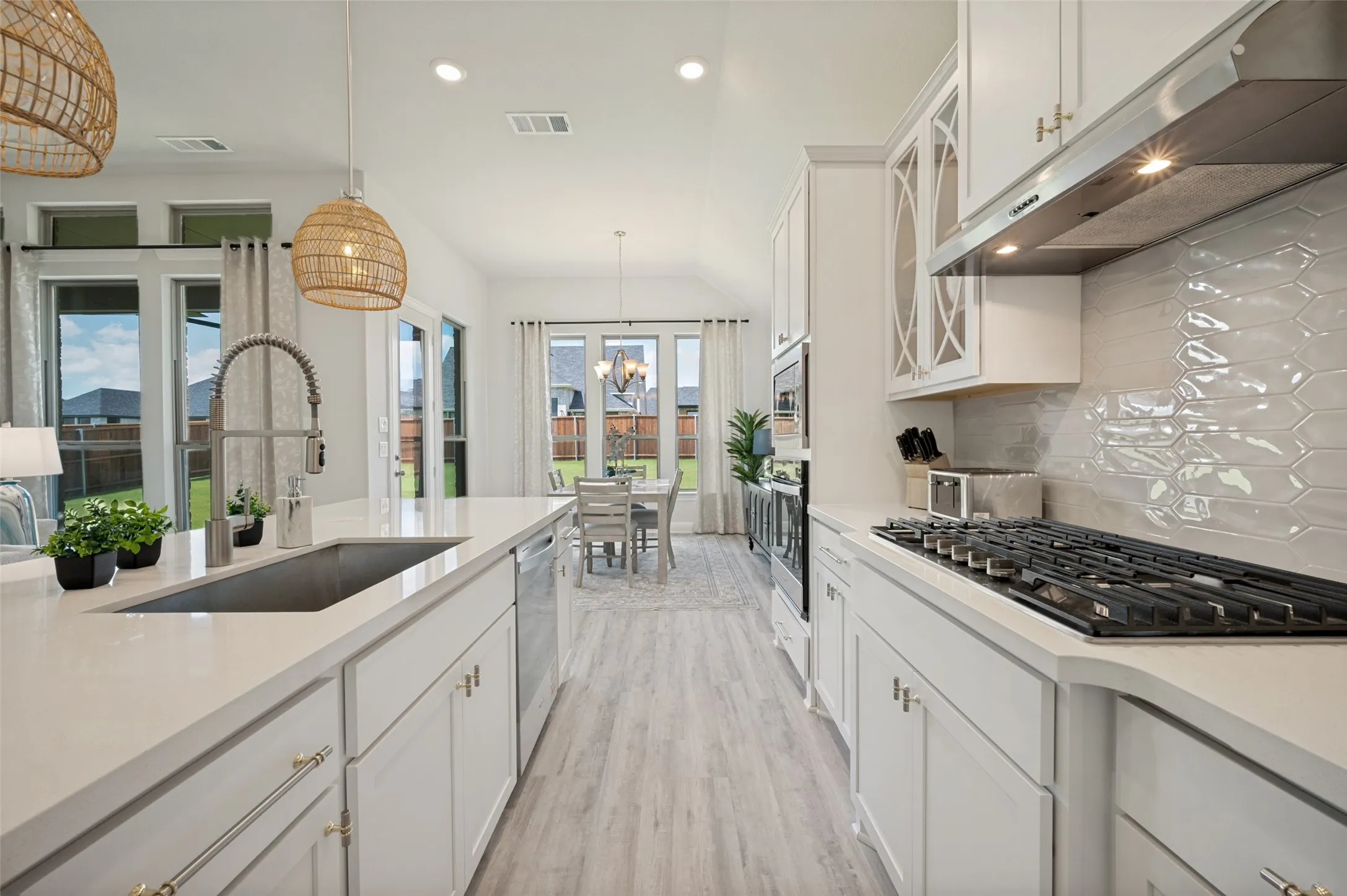 Designed with both beauty and functionality in mind, this gourmet kitchen showcases an oversized quartz island, double ovens, stainless steel appliances, designer lighting, and extensive cabinetry. The open-concept layout creates a seamless flow for entertaining while providing a sophisticated space for everyday living