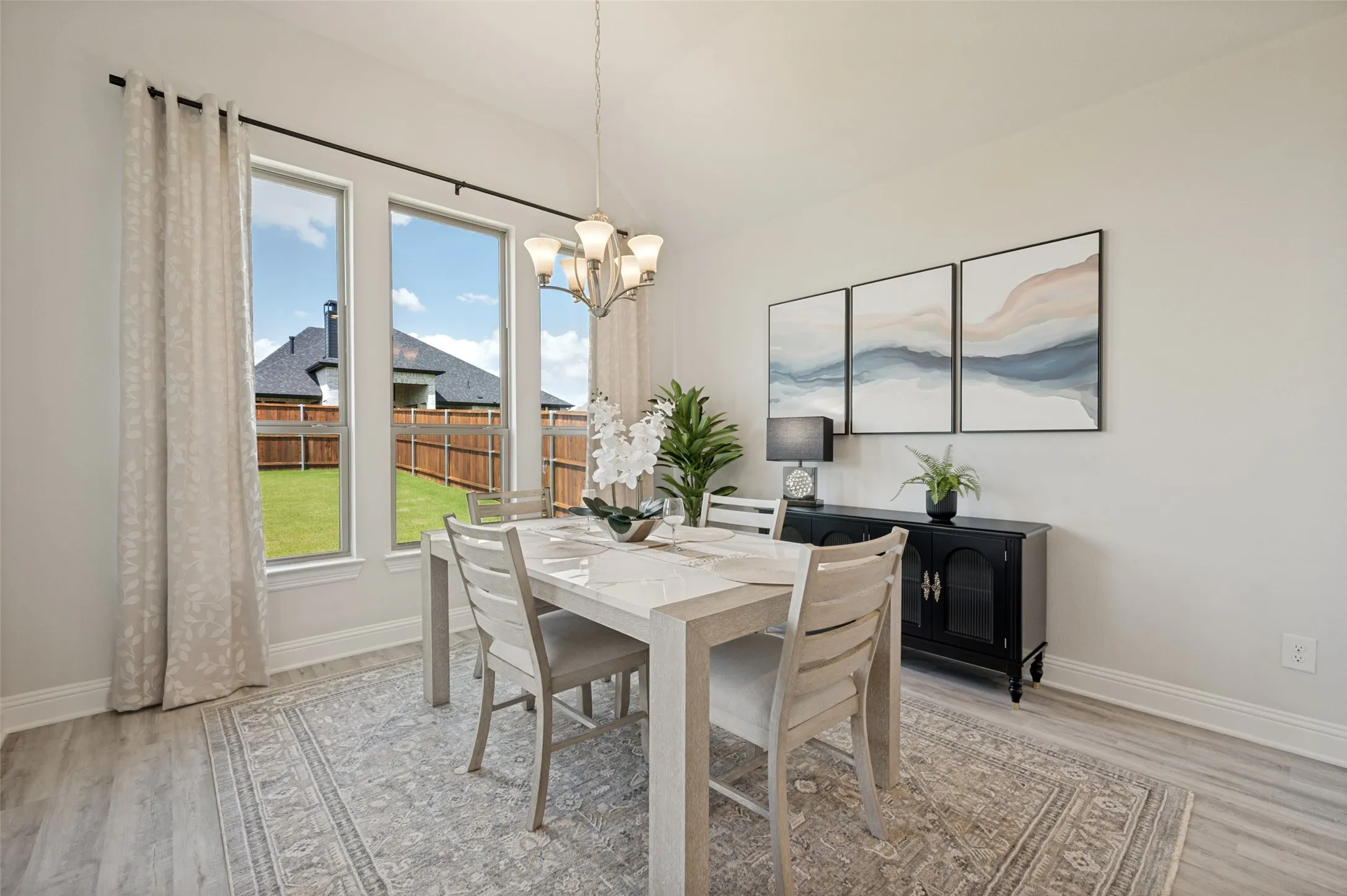 Surrounded by natural light and enhanced by soaring ceilings, this inviting dining space offers the perfect setting for everyday meals and memorable celebrations. Expansive windows frame peaceful backyard views while the open layout provides a seamless flow to the gourmet kitchen, creating an ideal environment for entertaining.