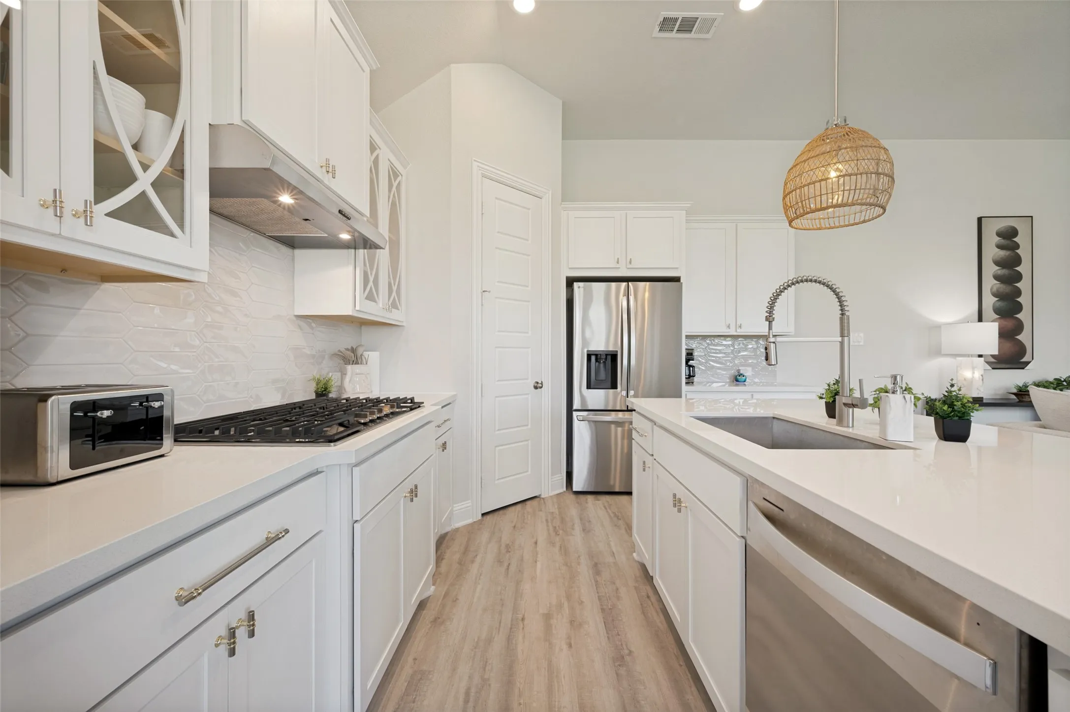 A true showpiece, this gourmet kitchen showcases quartz countertops, custom cabinetry with glass accents, stainless steel appliances, and a statement farmhouse sink. Designer lighting and thoughtful details elevate the space, while the expansive island creates the perfect gathering place for entertaining and everyday living