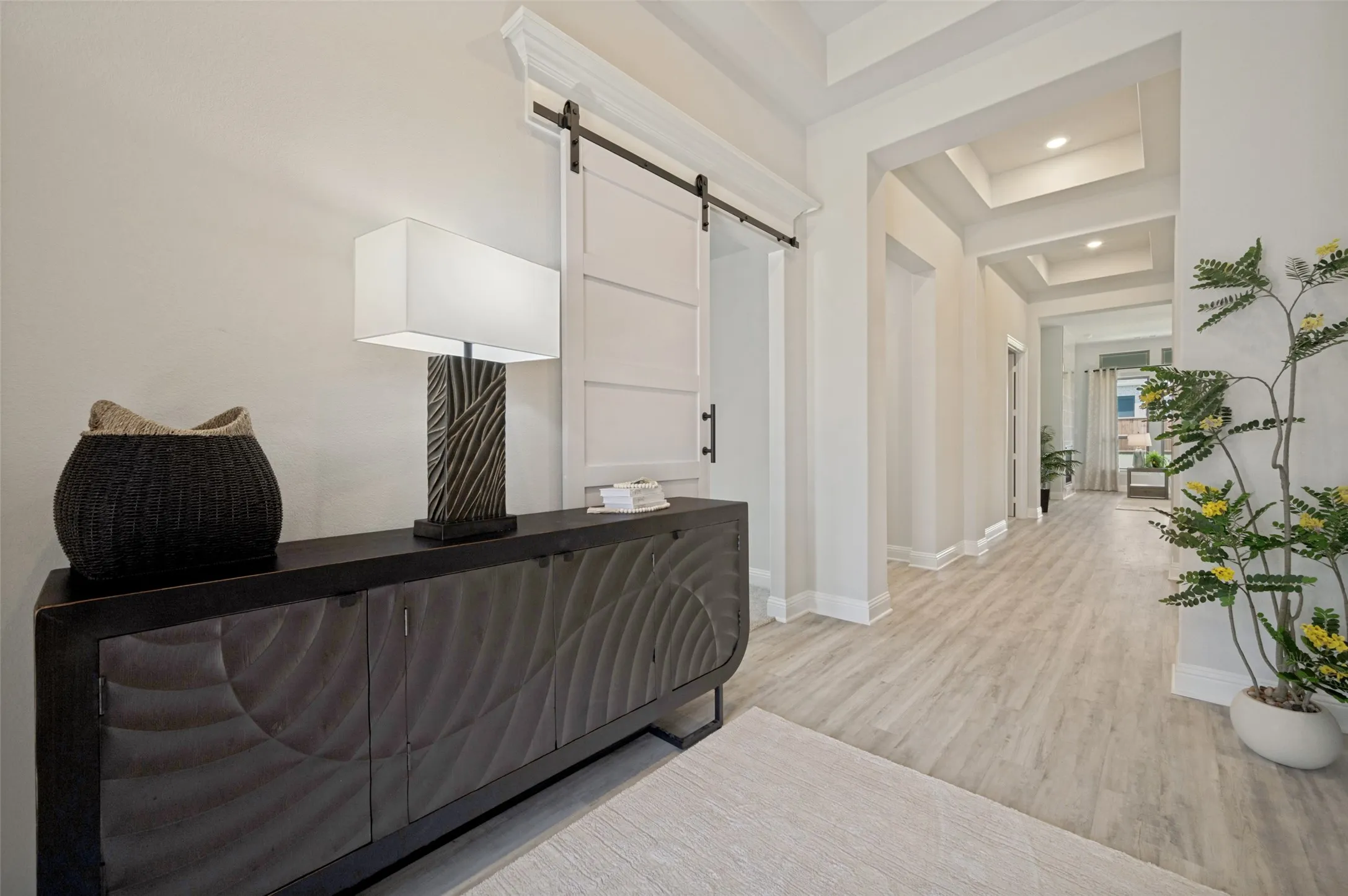 Step into a grand foyer where soaring ceilings, abundant natural light, and elegant architectural details create an unforgettable first impression. The contemporary front door, designer finishes, and thoughtfully curated accents set the tone for the sophisticated style and exceptional craftsmanship showcased throughout the home.
