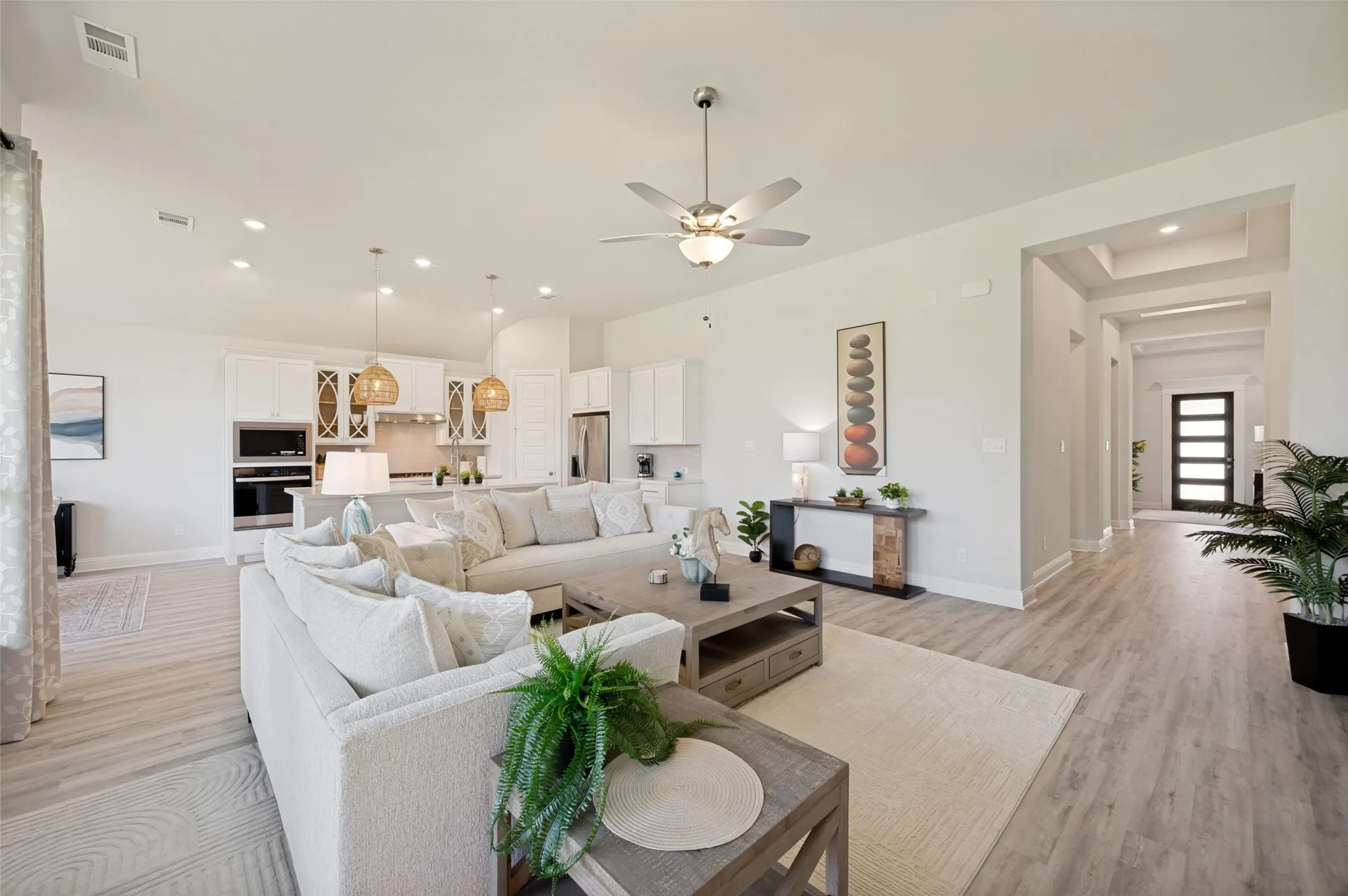 Designed for modern living, this expansive great room showcases soaring ceilings, designer finishes, and a seamless connection to the gourmet kitchen. Filled with natural light and offering exceptional functionality, the space is perfect for entertaining or relaxing. Even better, all living room furnishings convey with the home, providing unmatched value and convenience.