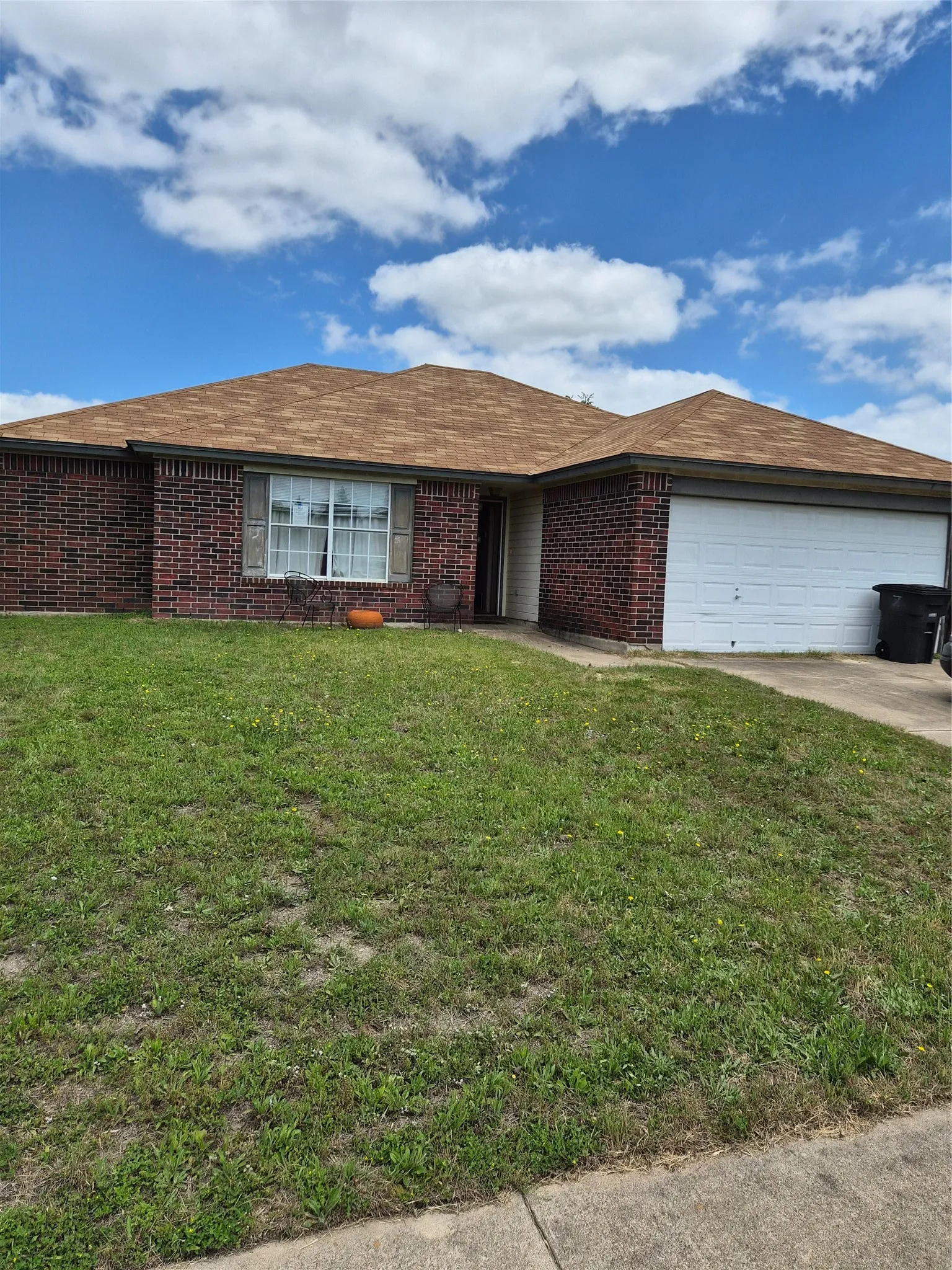 Brick exterior with a brown shingle roof