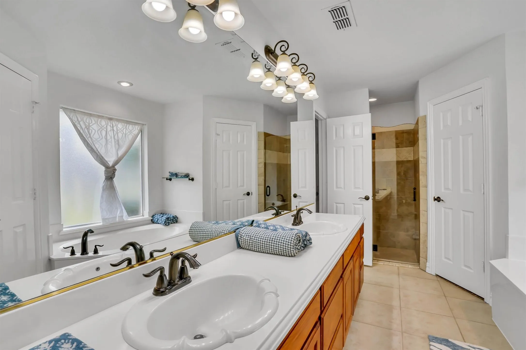 Dual sink vanity with white countertops and wood-finish cabinetry