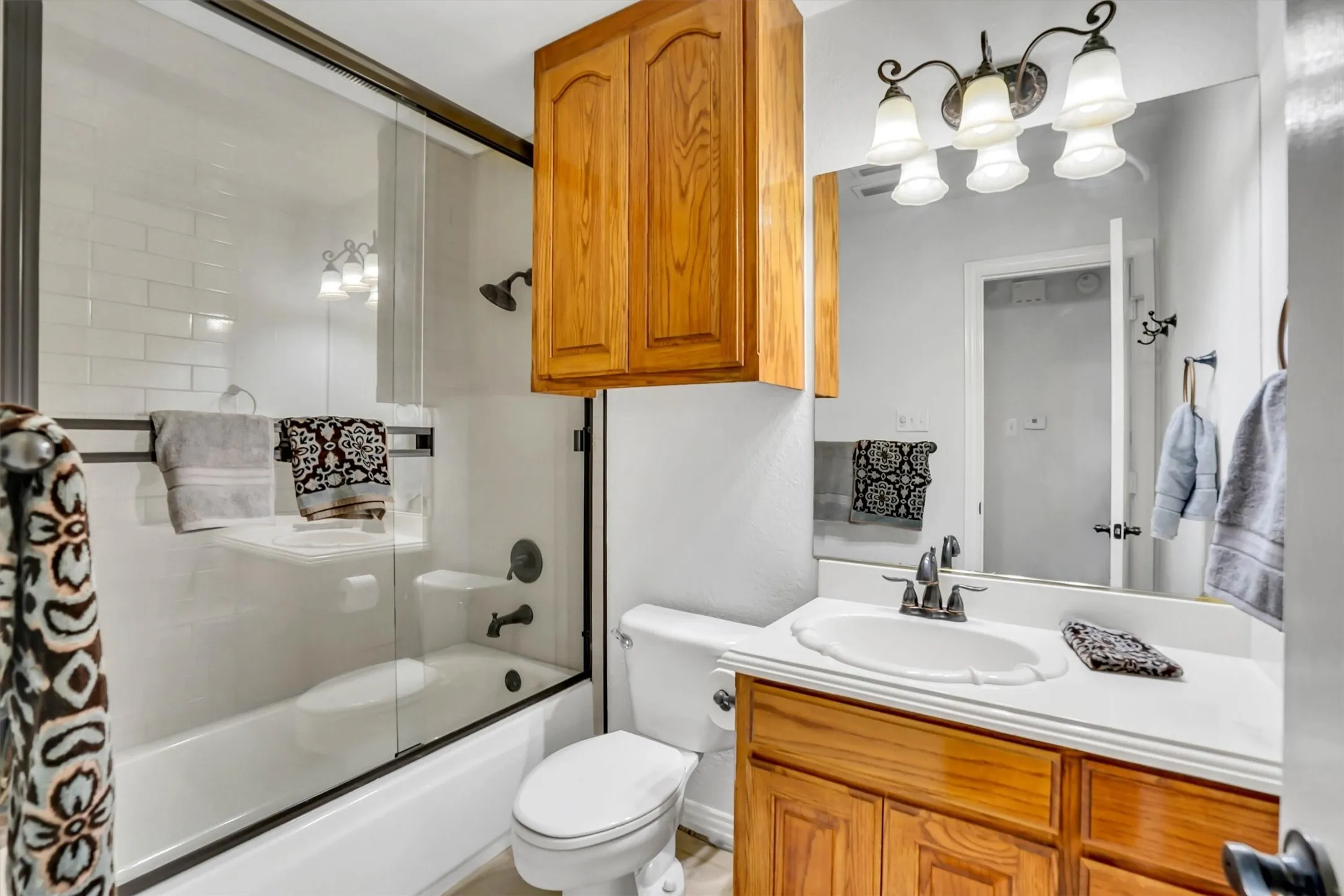 Bathroom featuring a tub/shower combination with subway tile surround and glass enclosure
