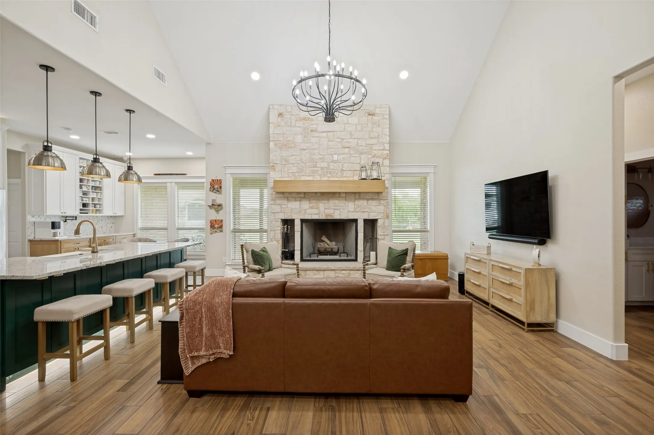 Notice the expansive breakfast bar in this photo.  In front of each bar stool are cabinets that open for additional storage.  Notice the stylish pendant lights that illuminate the kitchen island.