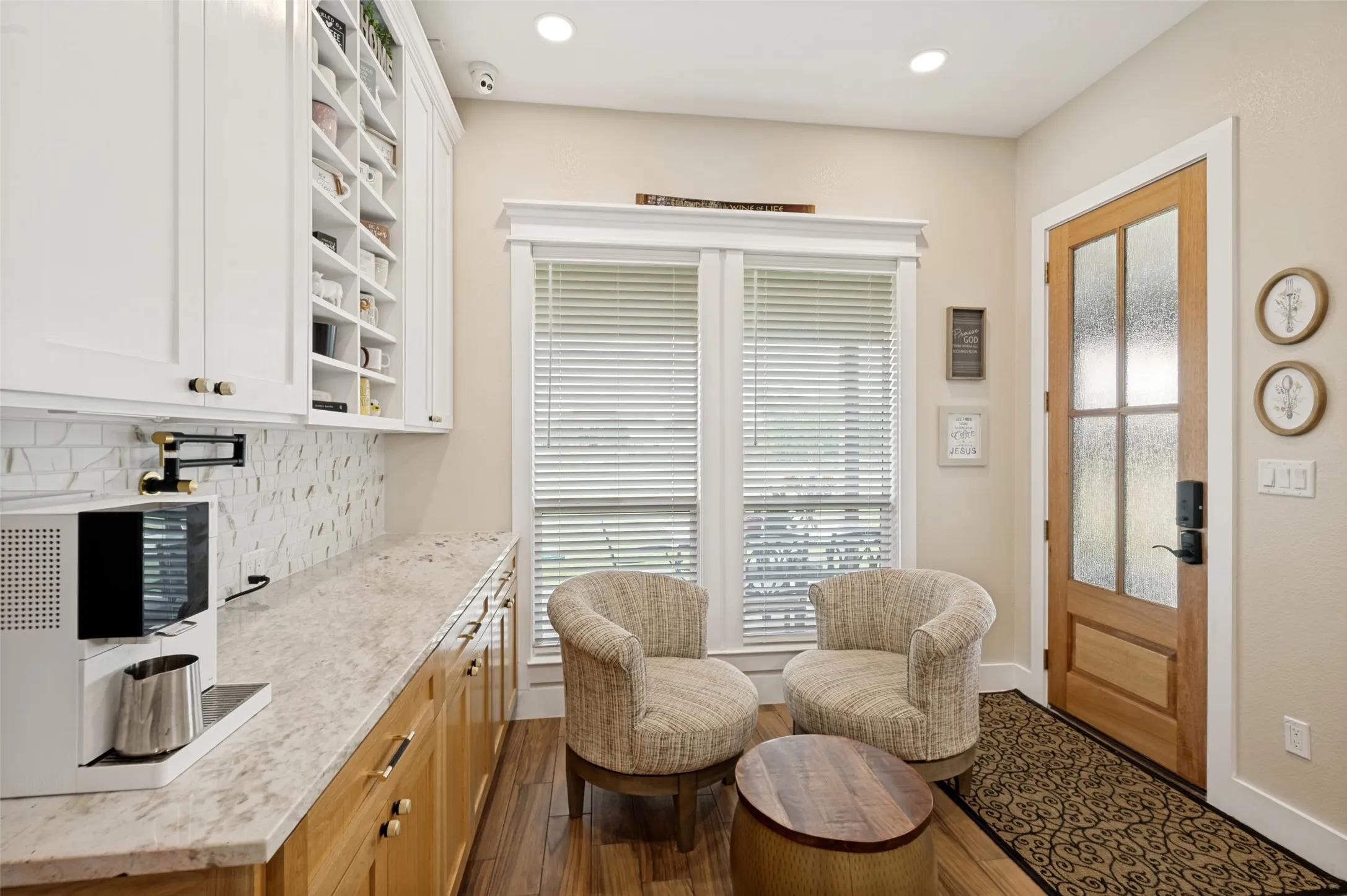 Tucked just off the kitchen, this charming breakfast nook offers a cozy and inviting space to start your day. Large windows fill the area with natural light, creating a bright and cheerful atmosphere while providing views of the outdoors. Notice the second built-in pot filler to your left making it so easy to prepare your morning coffee. This space has lots of great storage for your coffee mugs along with a nice expansive counter top for serving guests.  Beautiful view of the backyard.