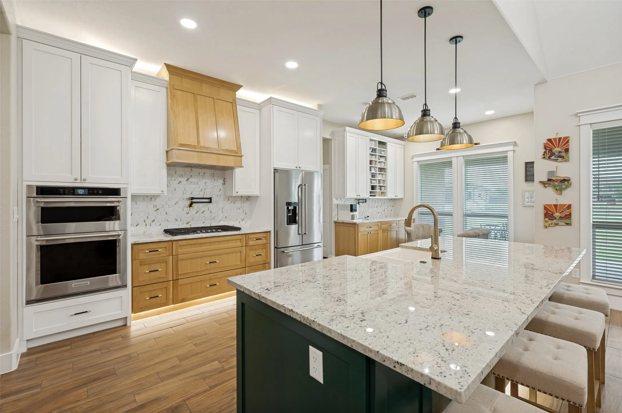 Crisp white cabinetry, designer lighting, and stainless steel appliances create a bright, timeless aesthetic, while abundant storage ensures both beauty and functionality.