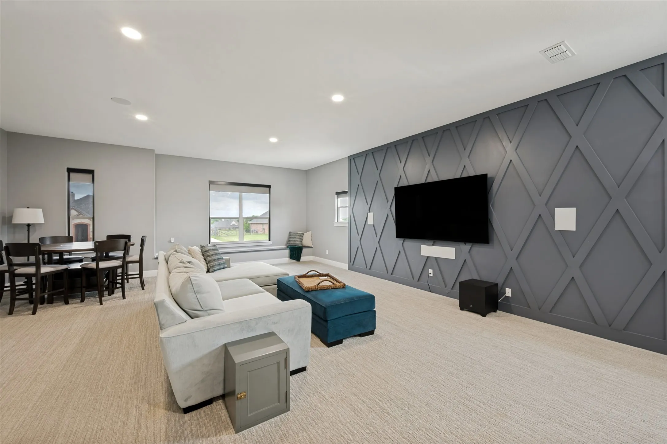 This expansive upstairs bonus room offers endless possibilities for entertainment, relaxation, and everyday living. Designed with versatility in mind, the spacious layout easily accommodates a media room, game room, home office, fitness area, or multi-purpose family retreat. The blinds are controlled remotely creating a true theatre feel. Large window seat offers additional seating as well as storage.  Television, speakers, surround sound equipment, and wine refrigerator at wet bar all stay with the house.