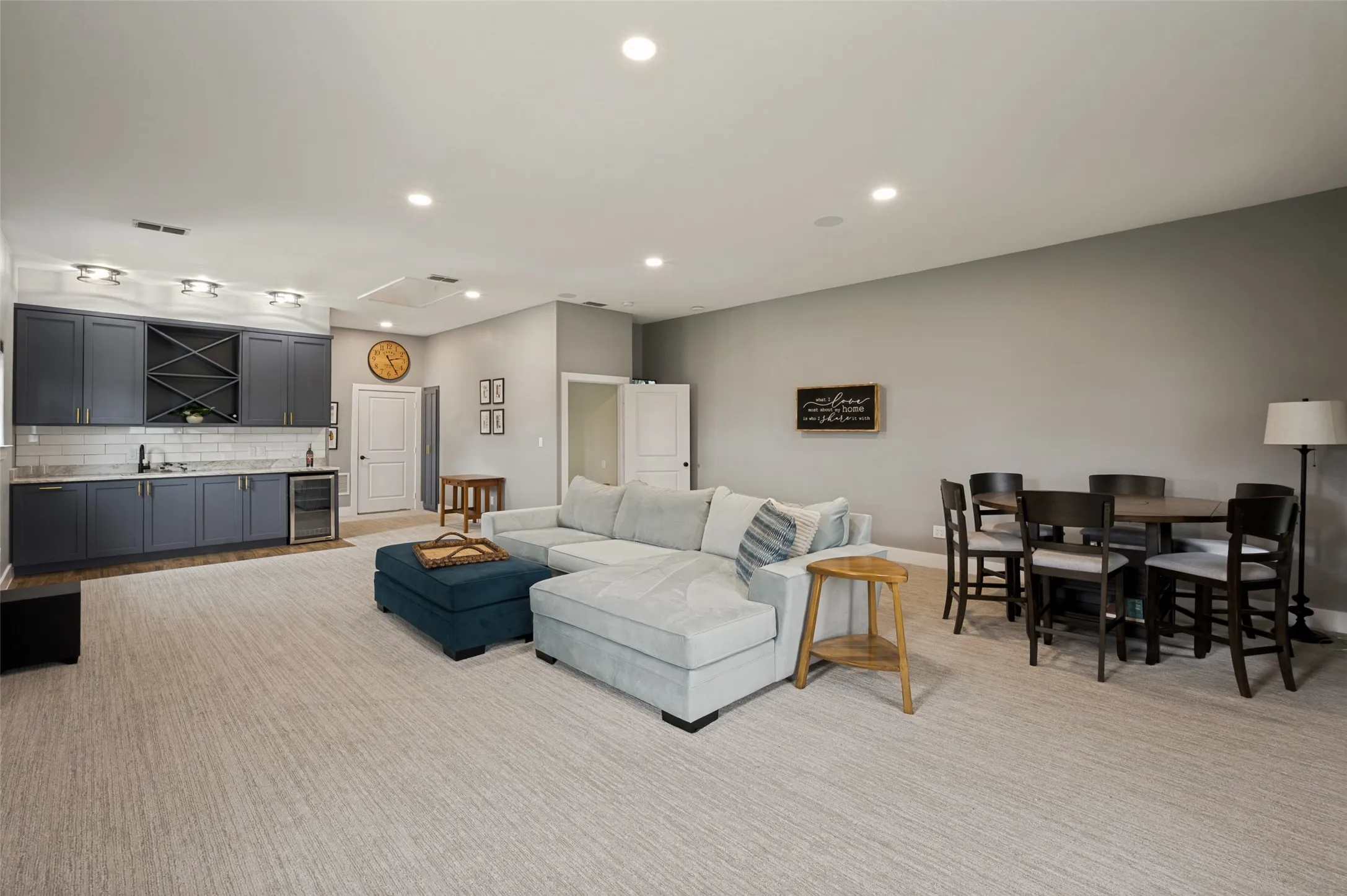 Comfortable, stylish, and highly functional, this flexible space is ready to adapt to your lifestyle. The custom cabinetry, wine refrigerator, wet bar, and beautiful lighting creates a space for all your entertaining needs. Open door to the far right leads to the stairwell.