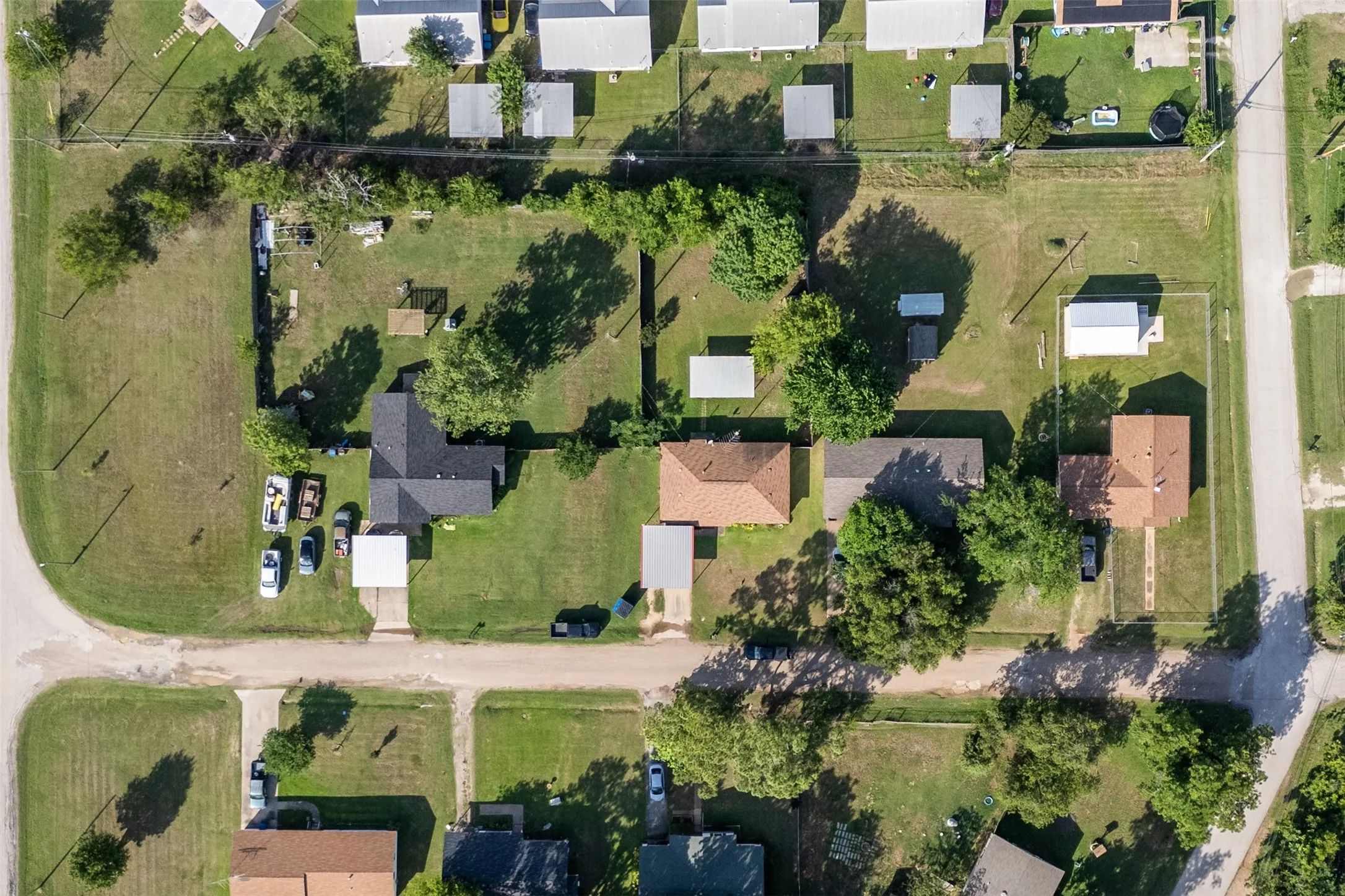 Aerial view showcasing a residential area with multiple single-story homes, established green spaces, and a consistent street grid