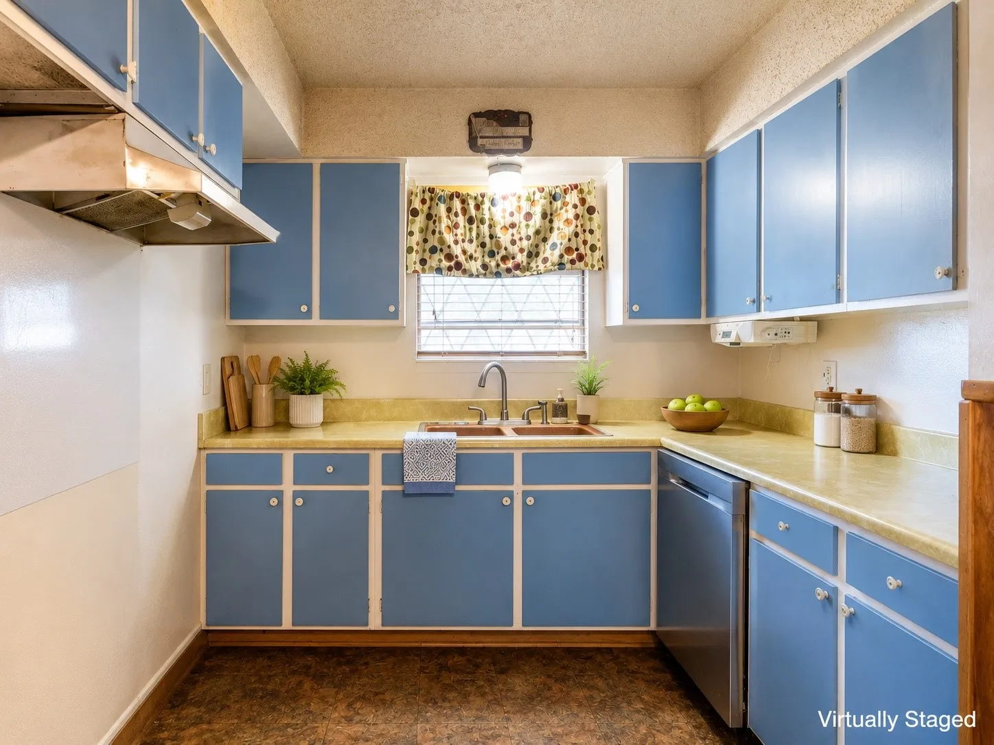 Kitchen featuring blue cabinetry with white trim, light-toned countertops, and a stainless steel dishwasher