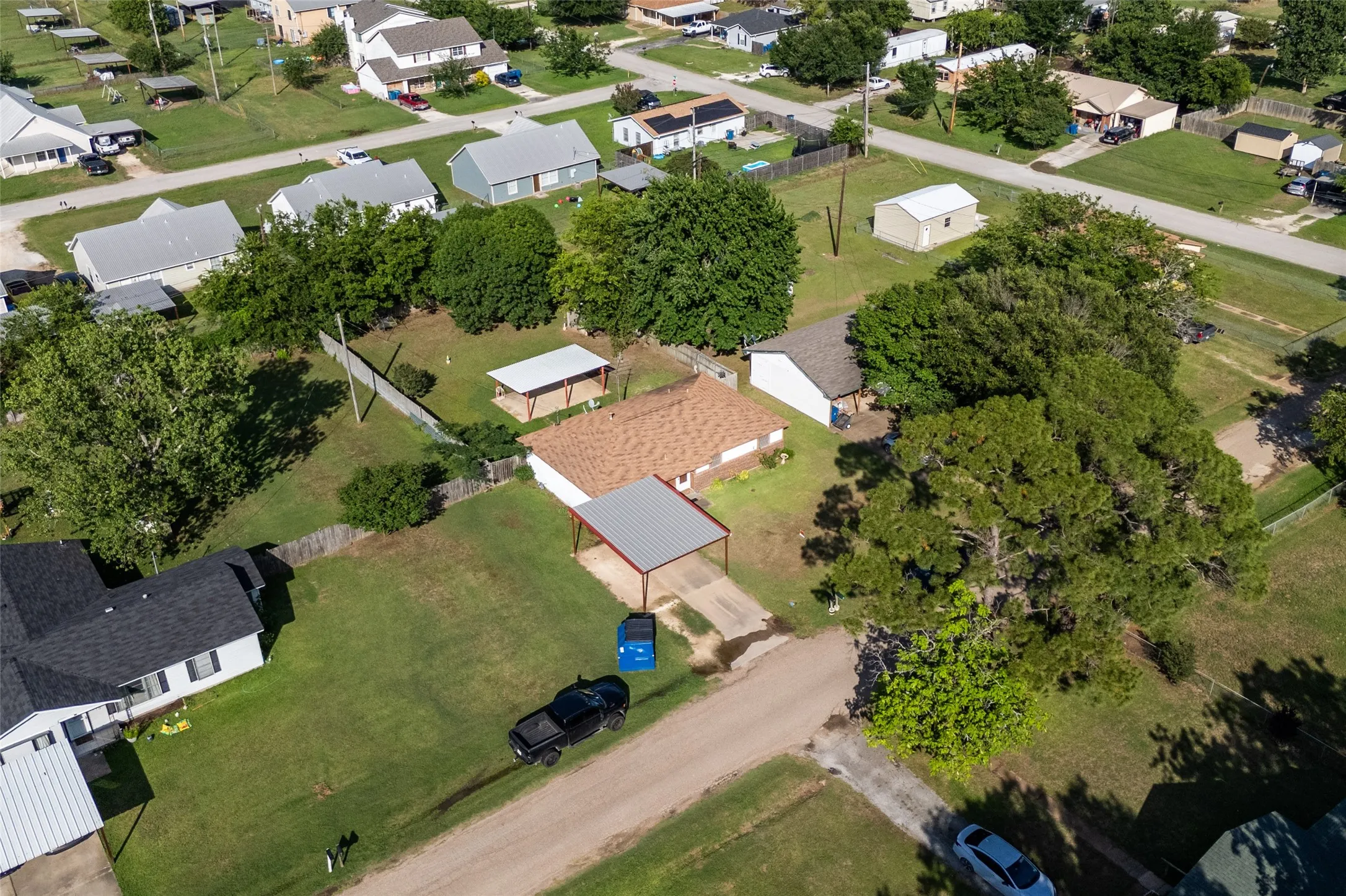 Residential property with a brown shingle roof and a covered carport