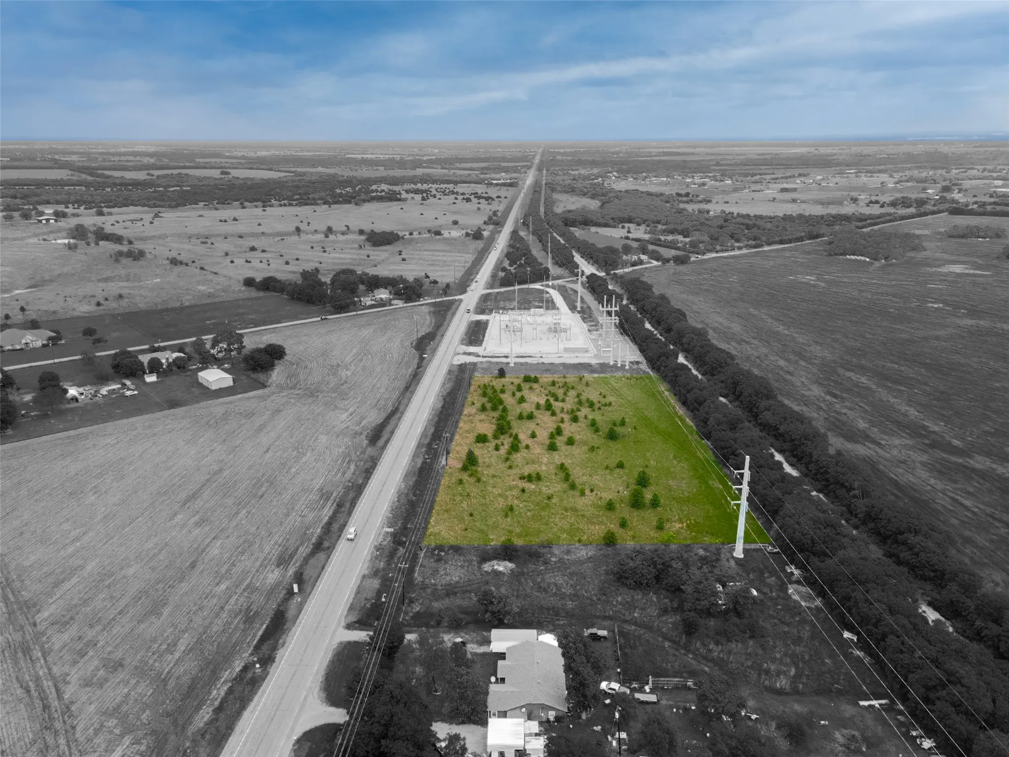 Expansive green parcel featuring varied tree coverage and direct road frontage