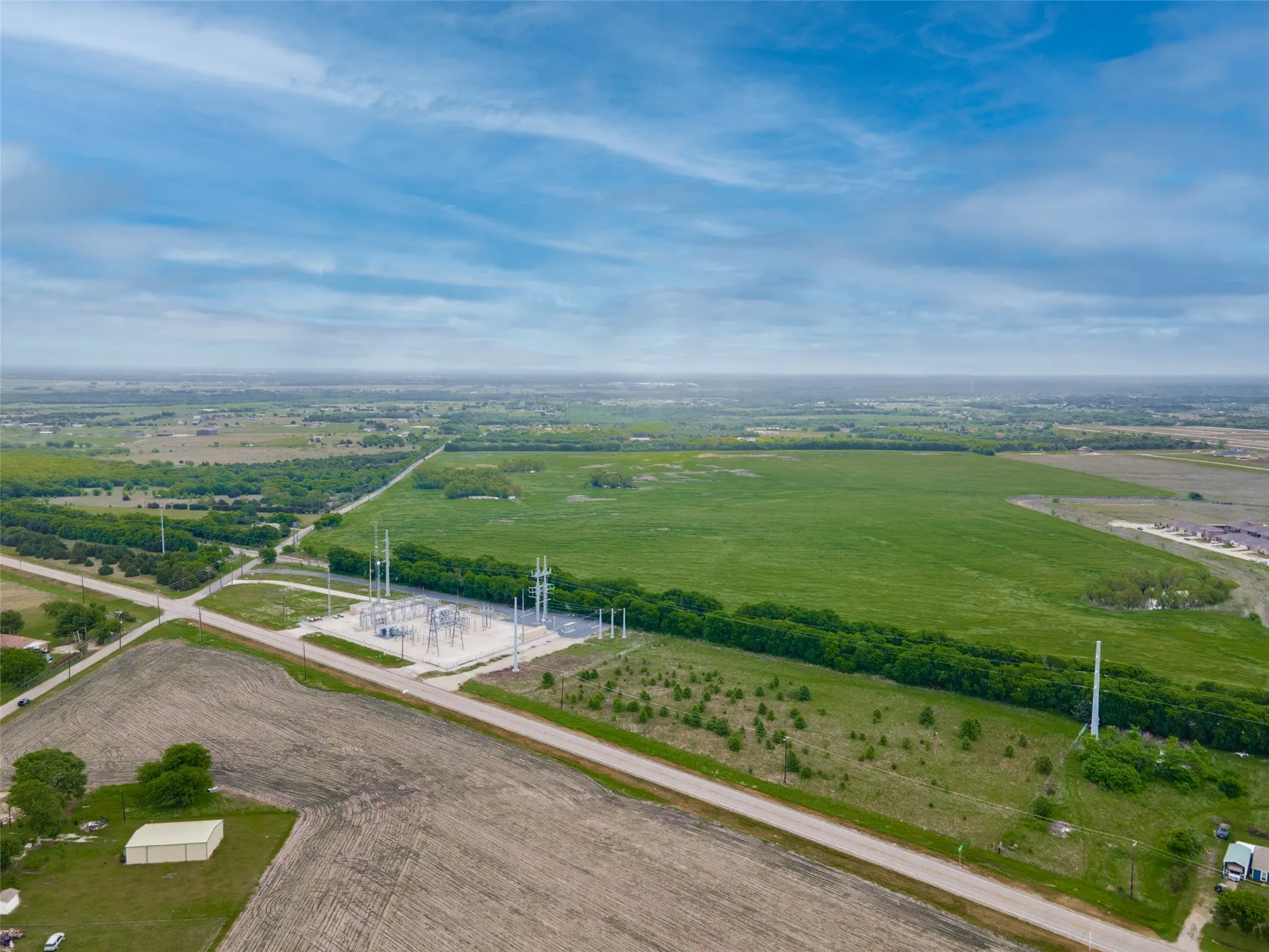 Expansive green fields with scattered tree lines