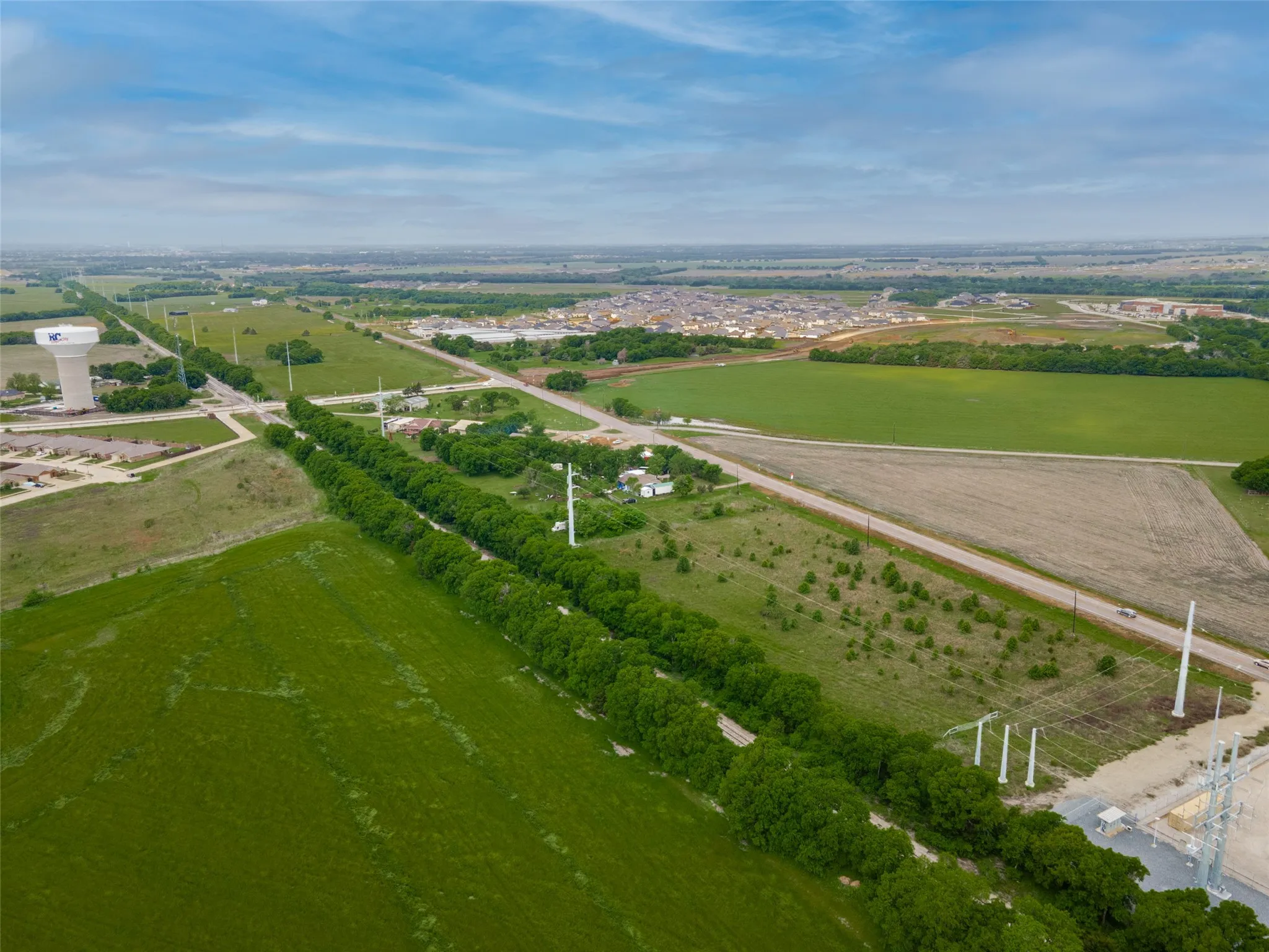 Expansive green fields with a visible road running through the landscape